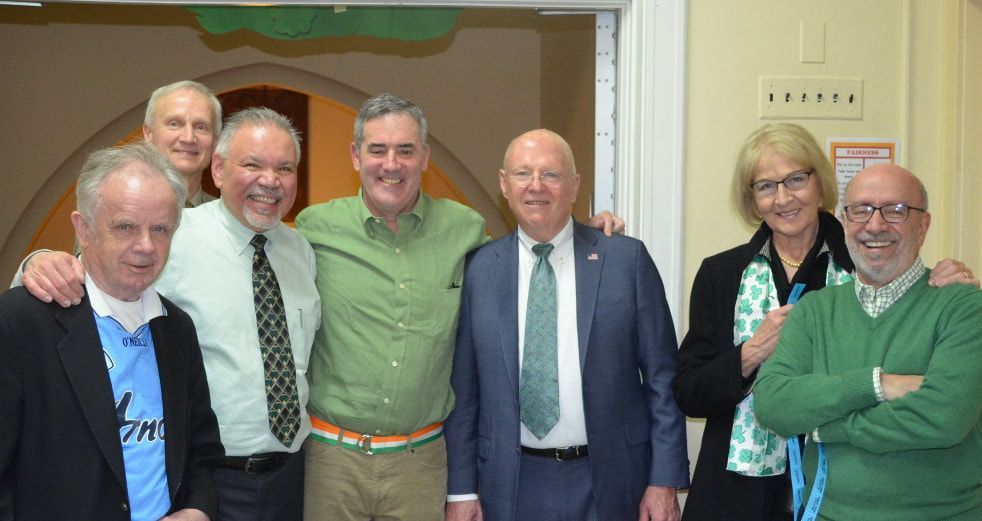 A group of men and women are posing for a picture together.
