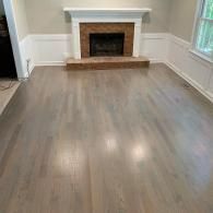 A bright living room with a brown brick hearth and white mantel.