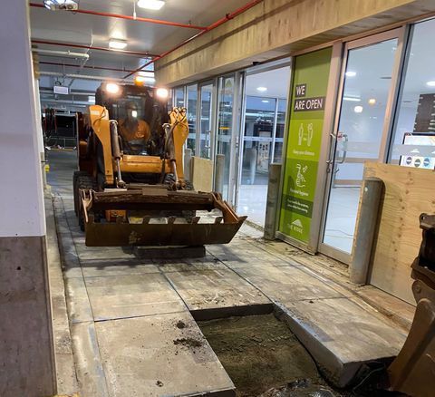 A bulldozer is digging a hole in the ground in a building.