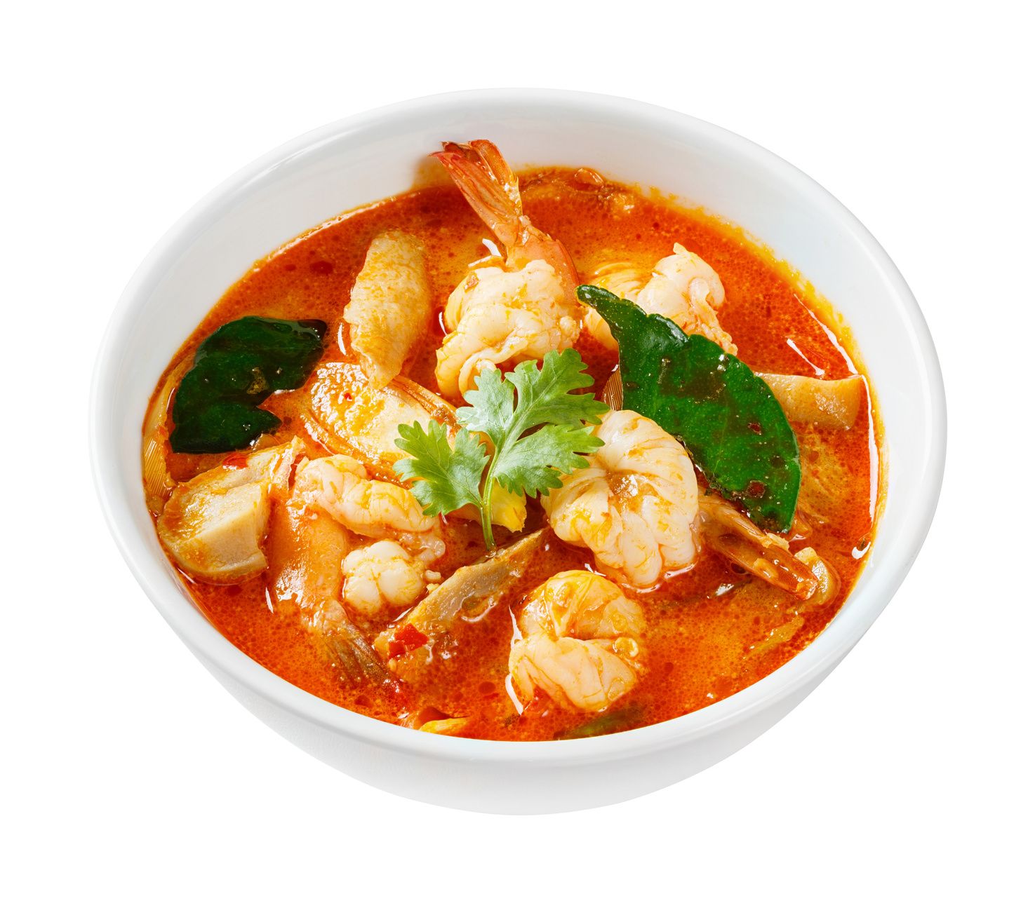 Bowl of Tom Yum soup with shrimp, mushrooms, and herbs.