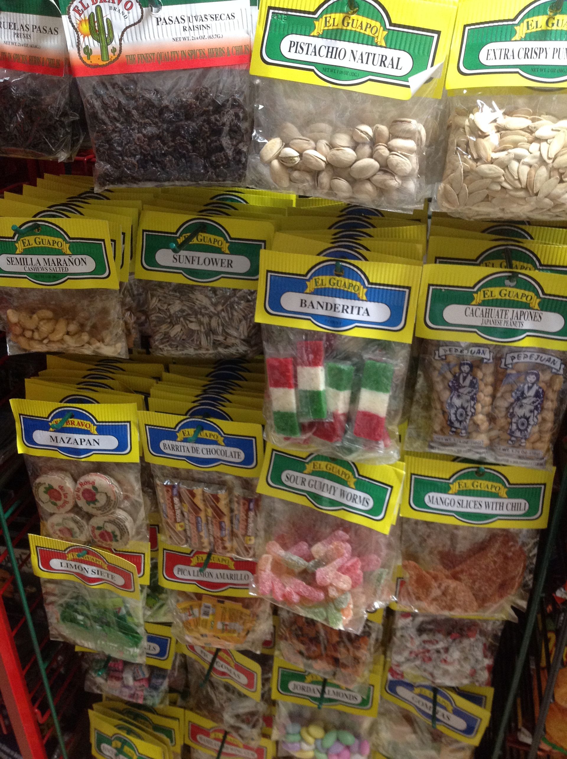 Shelves with various snack-sized bags. Nuts, candies, and dried fruit are visible, with yellow and green labels.