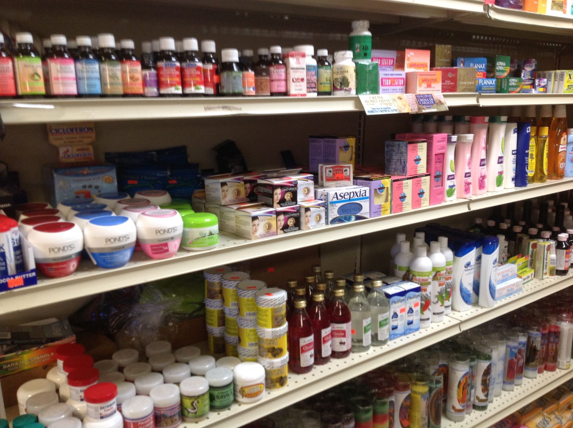 Shelves stocked with various bottles, jars, and boxes of health and beauty products inside a store.