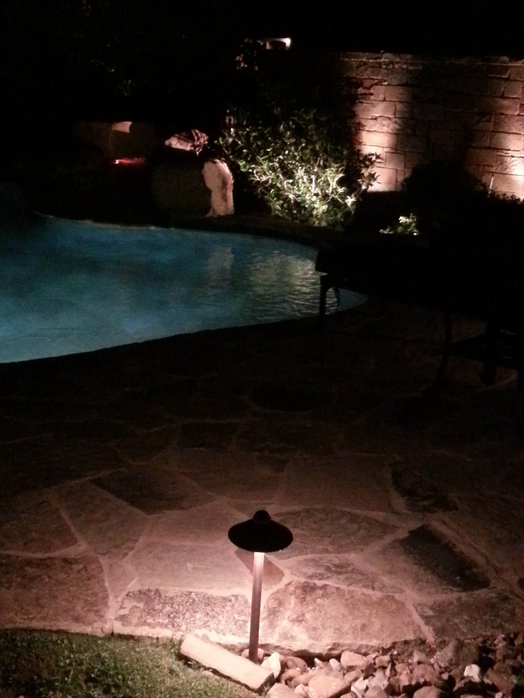 Ambient exterior lighting beside a swimming pool. 