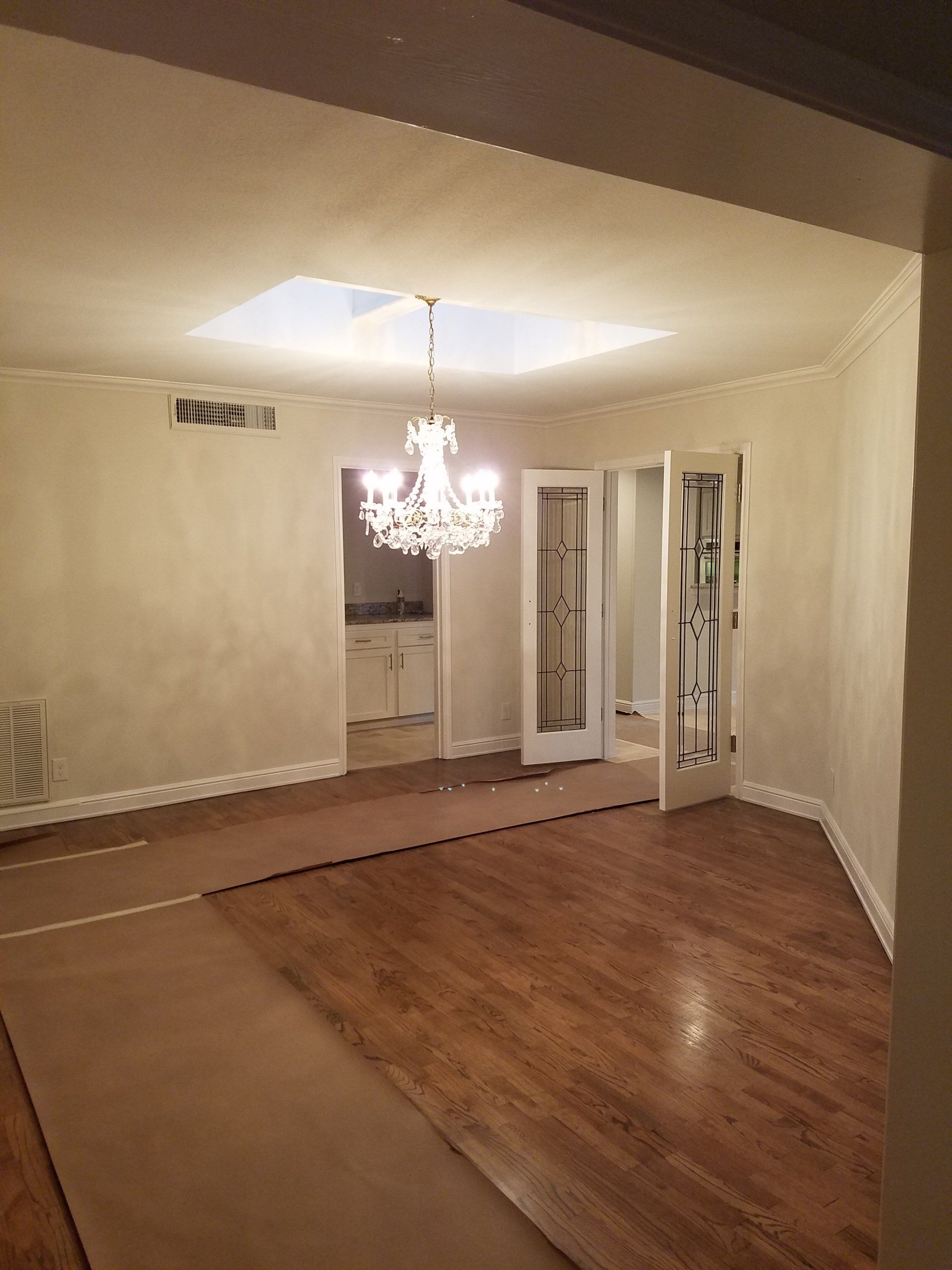 Chandelier hanging in an empty dining room.
