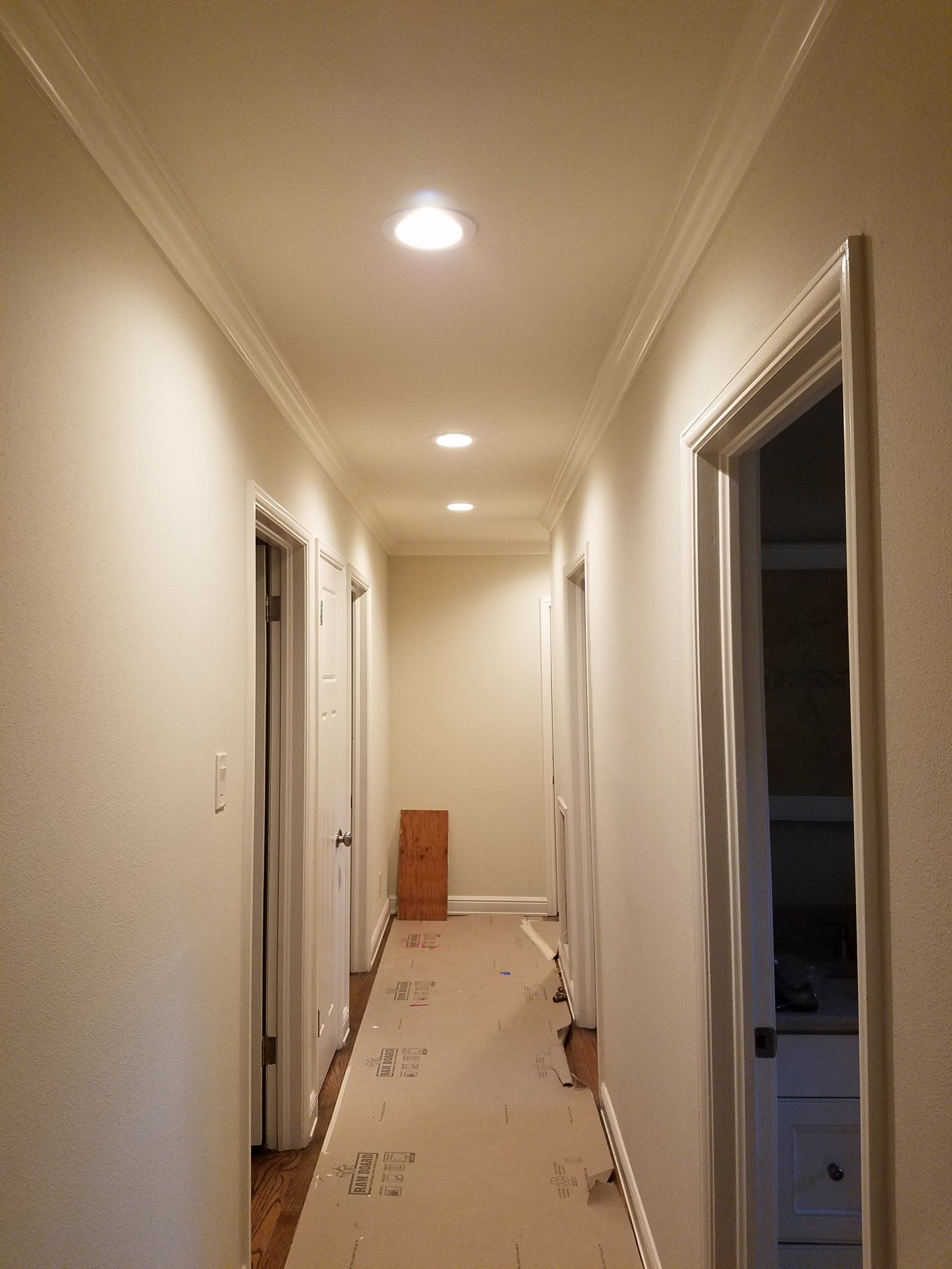 Recessed lighting in the hallway of a home.
