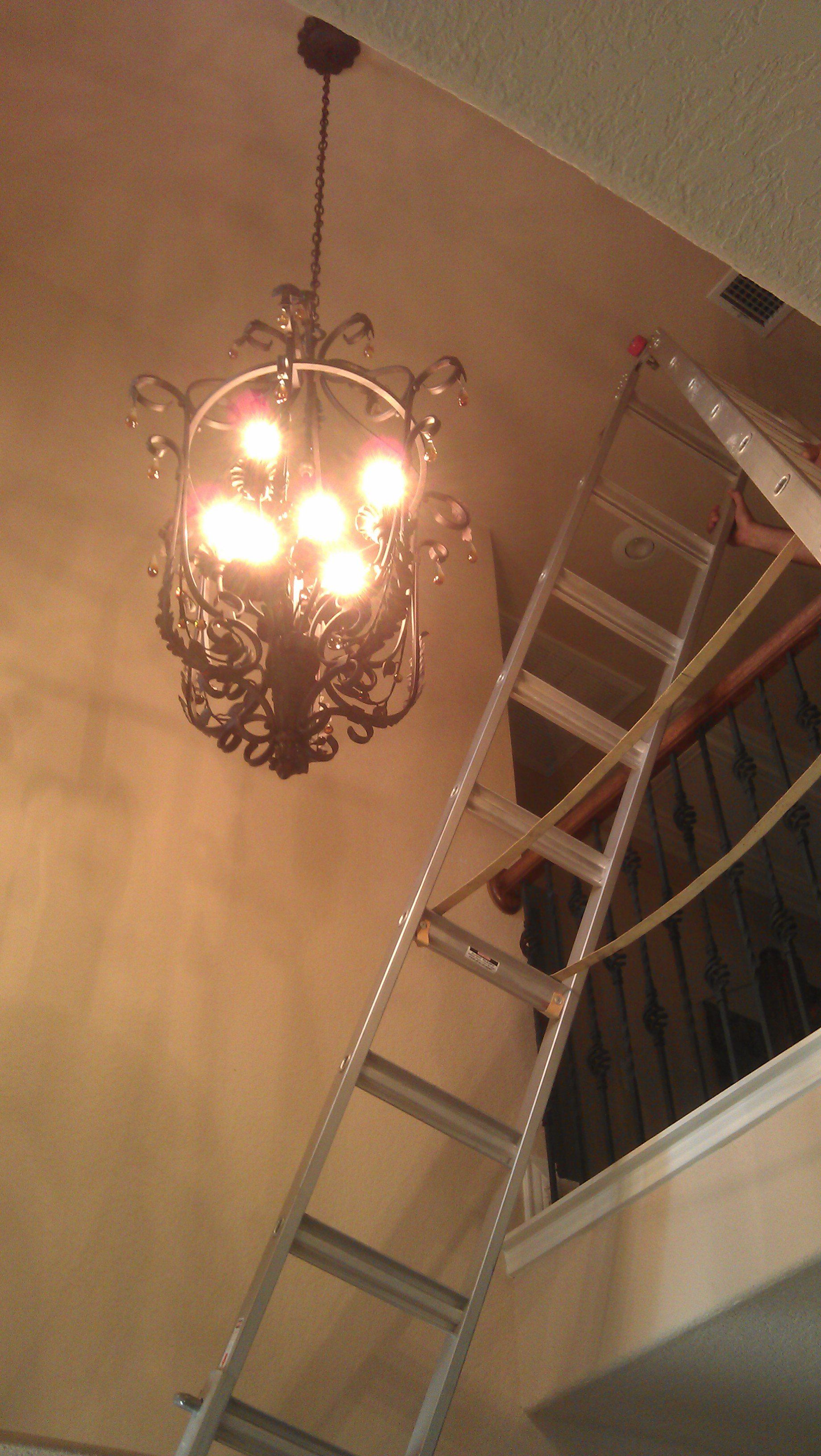 Installing a fancy chandelier in a two story foyer.