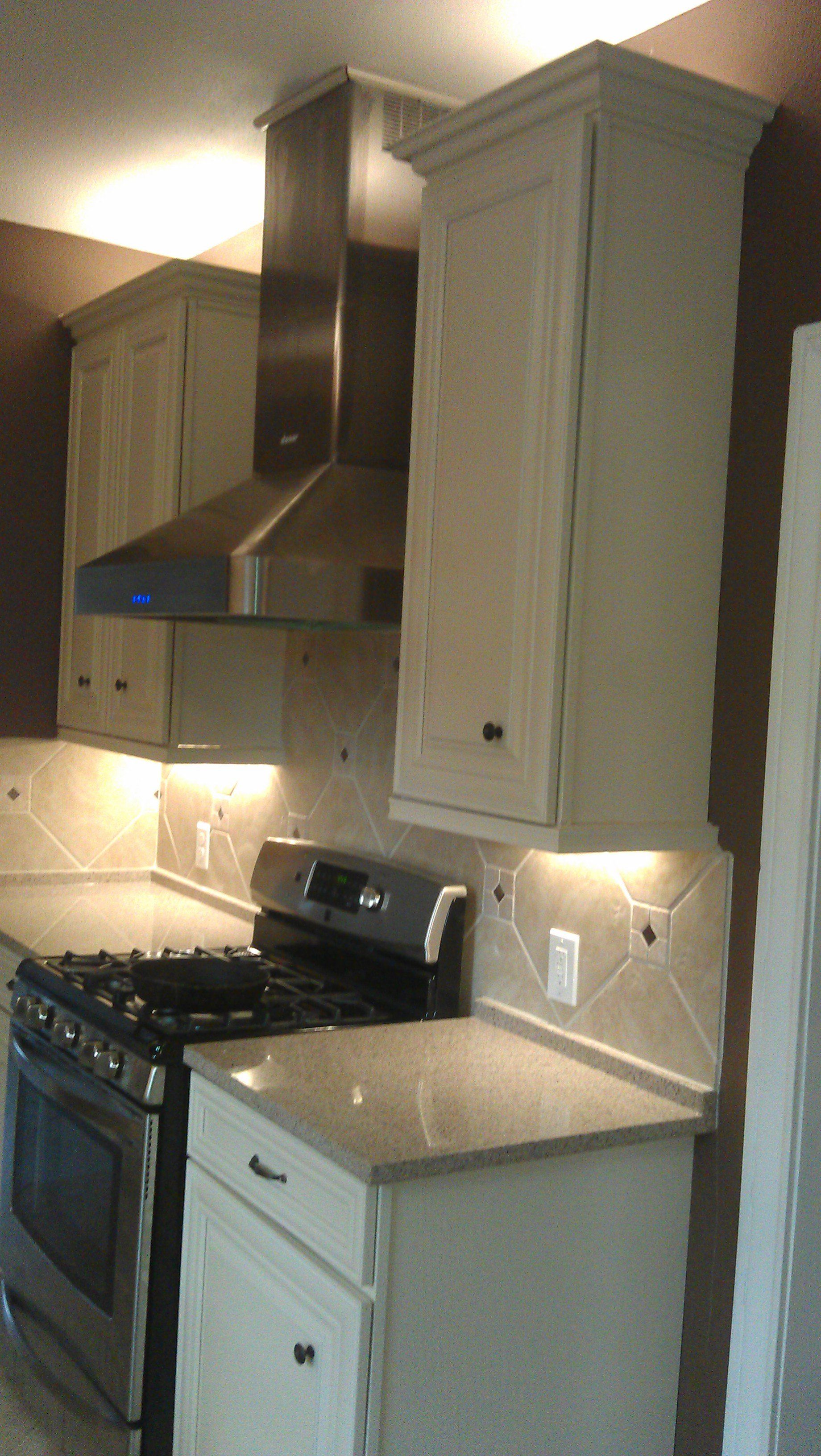 White kitchen cabinets with hardwired puck lighting under the cabinets.