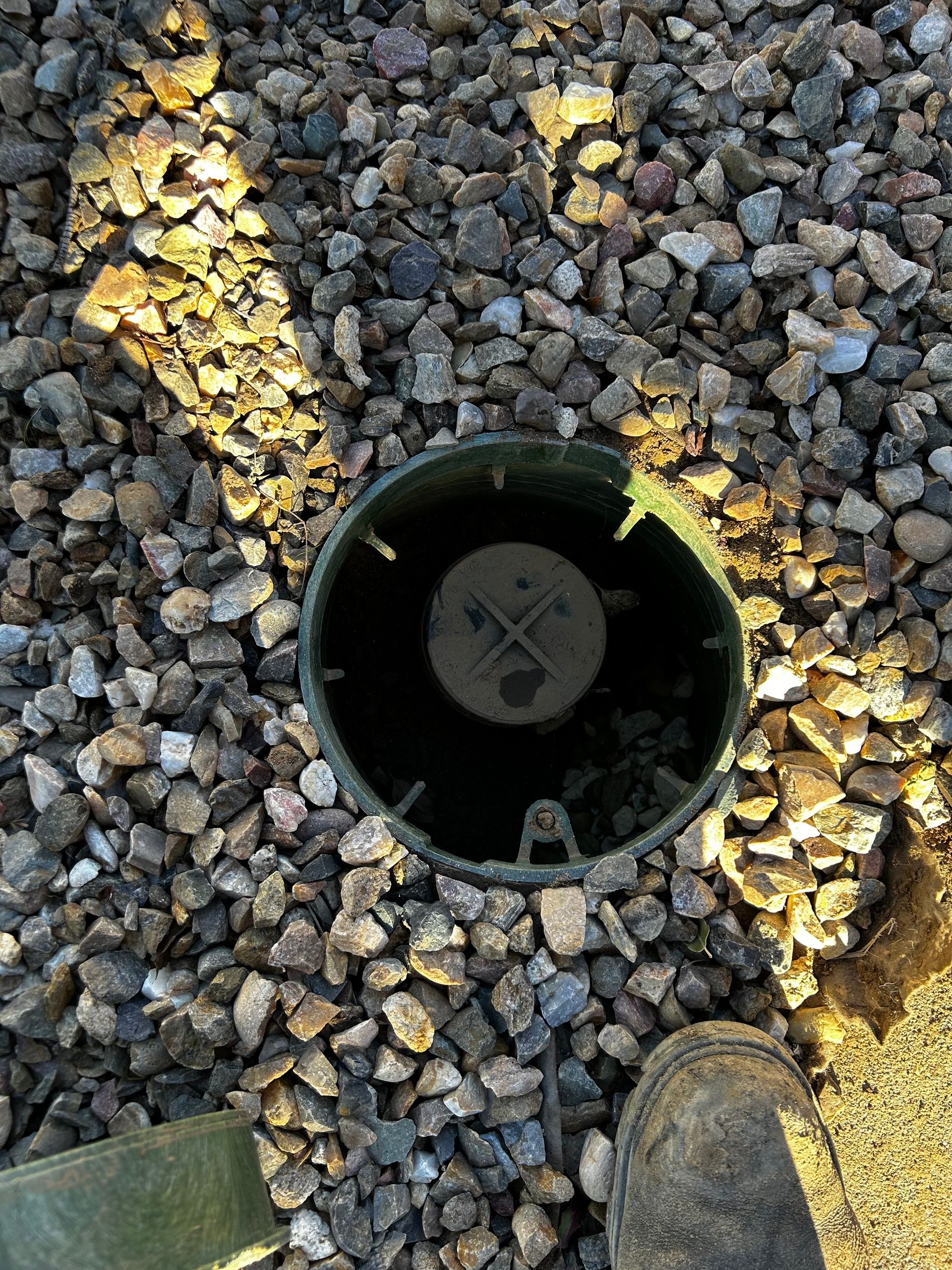 A person is standing next to a hole in the ground.