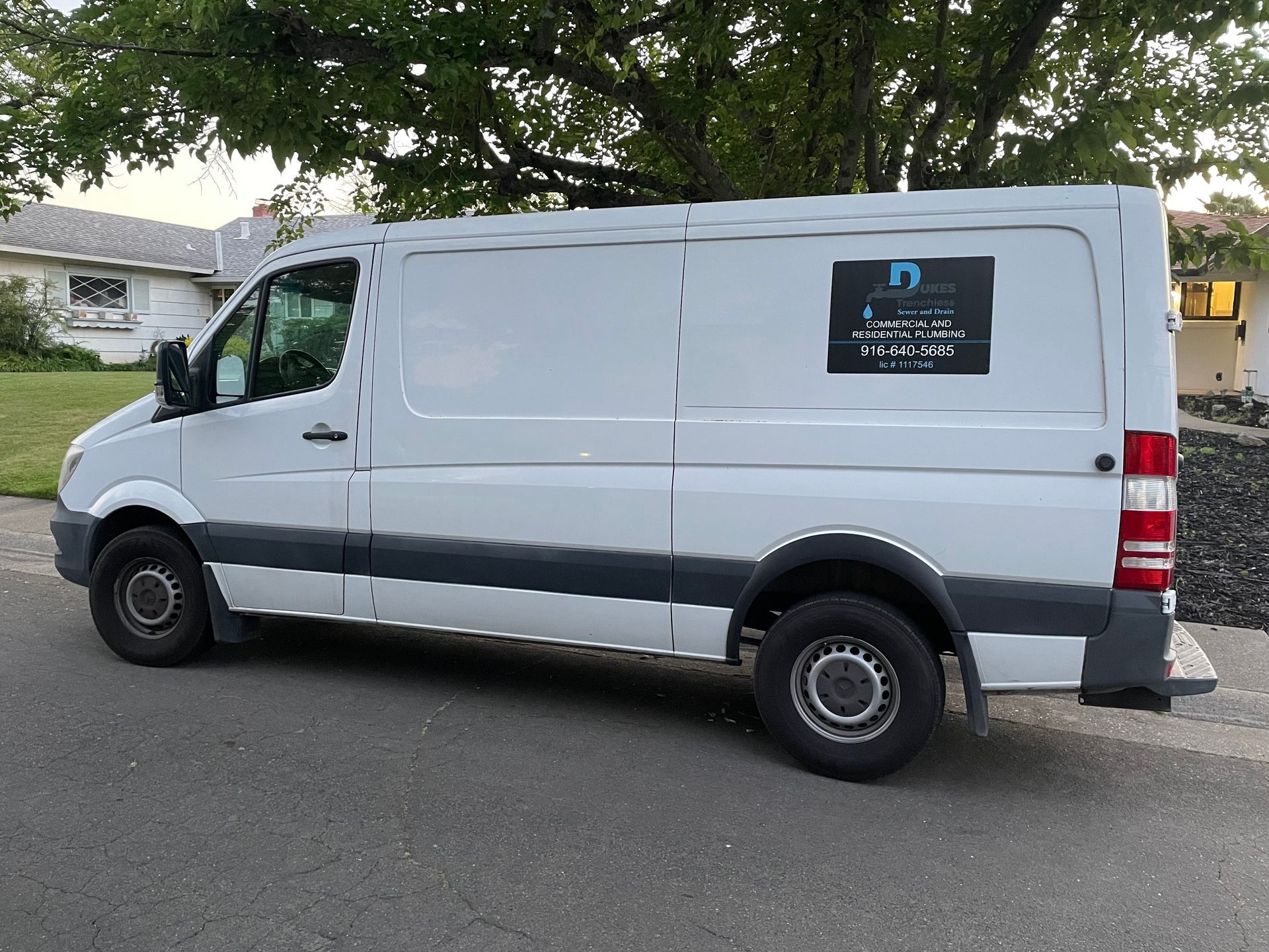 A white van is parked on the side of the road.