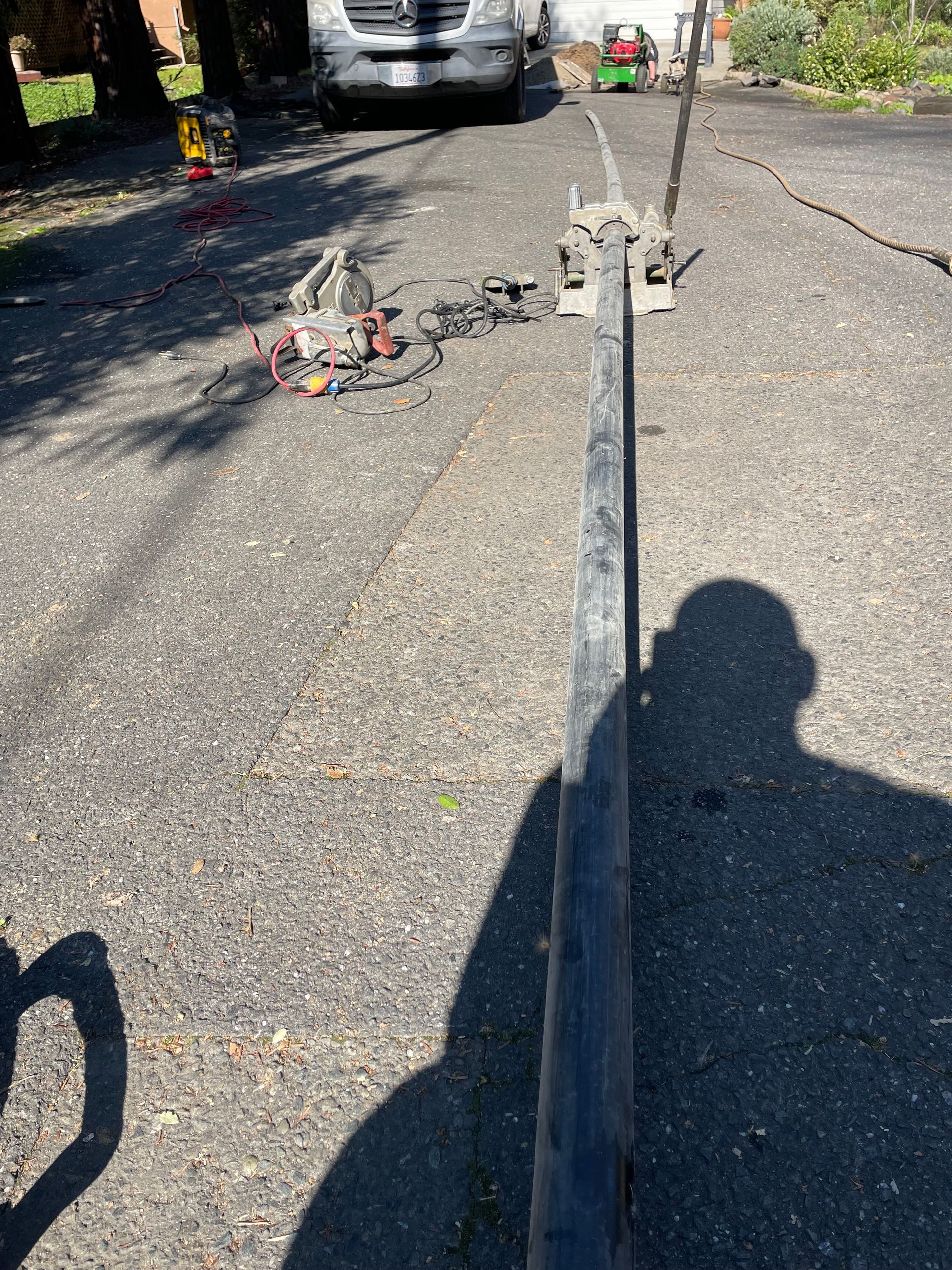 A car is parked on the side of the road next to a metal pole.