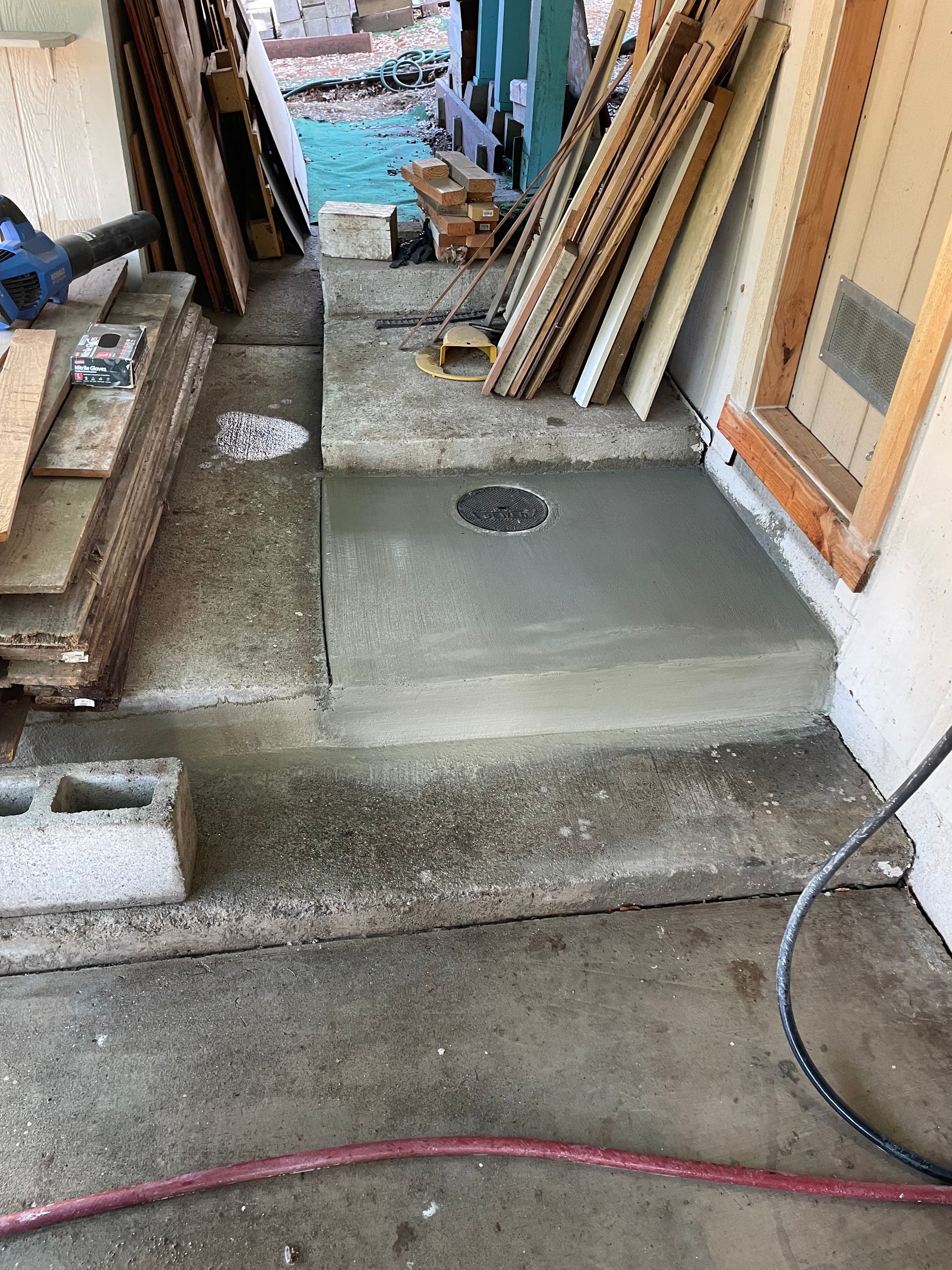 A concrete floor with a hole in it is being built in a garage.