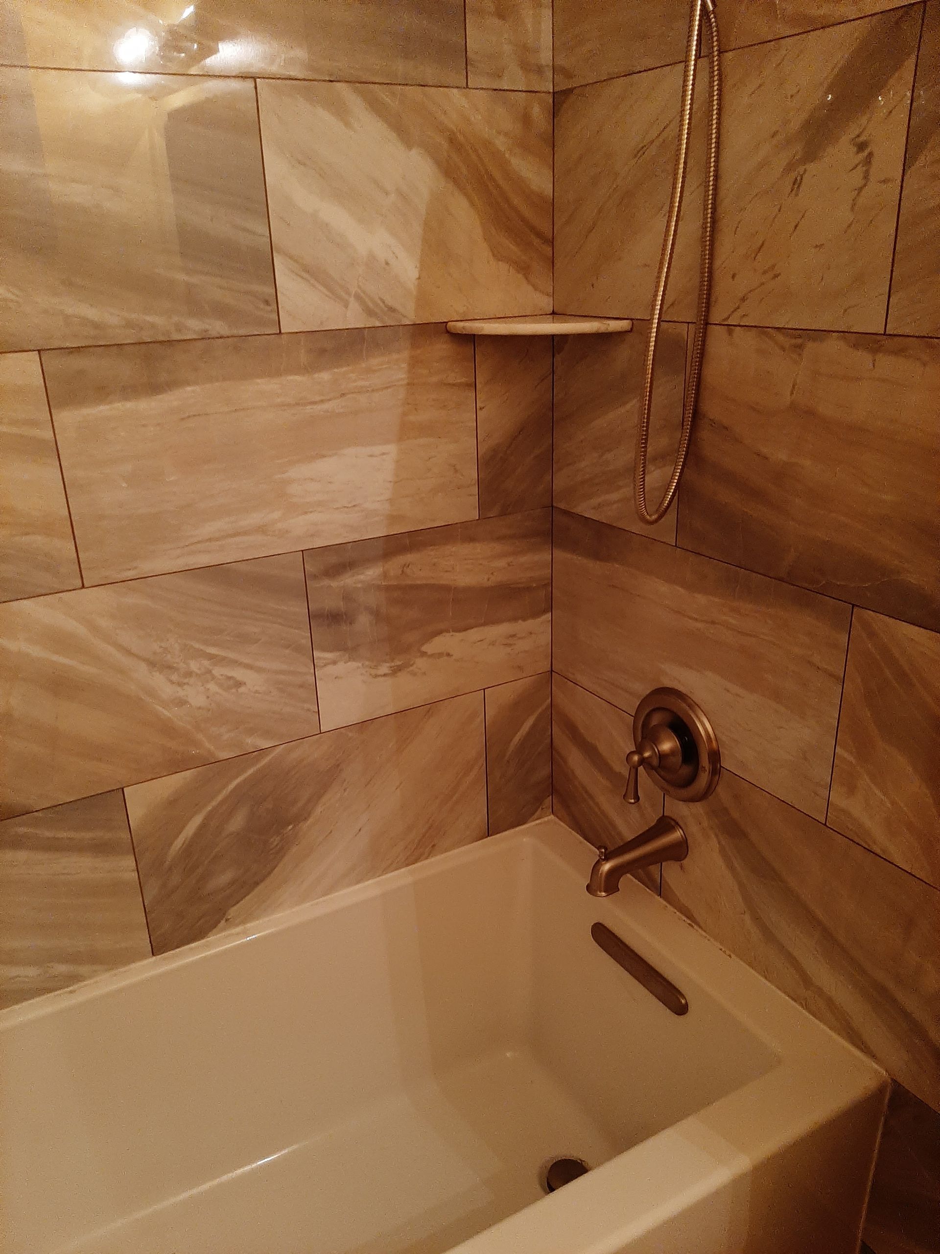 A bathtub in a bathroom with marble tiles