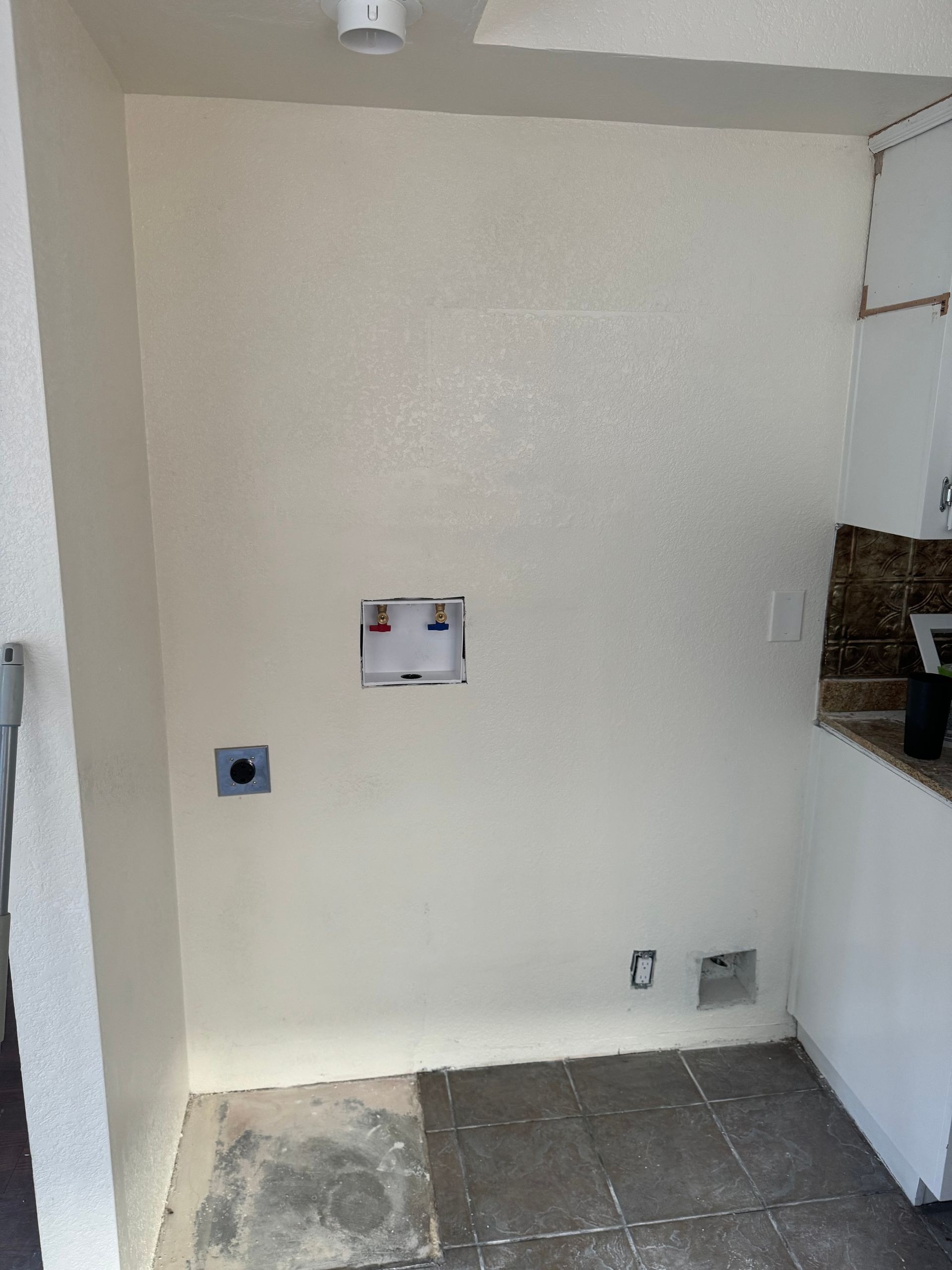 There is a hole in the wall for a washer and dryer.