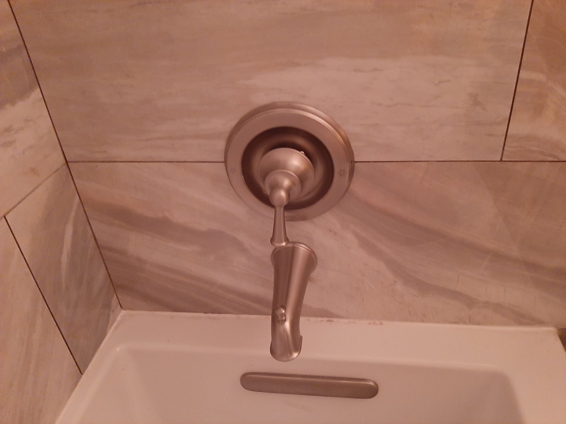 A close up of a bathtub faucet in a bathroom.