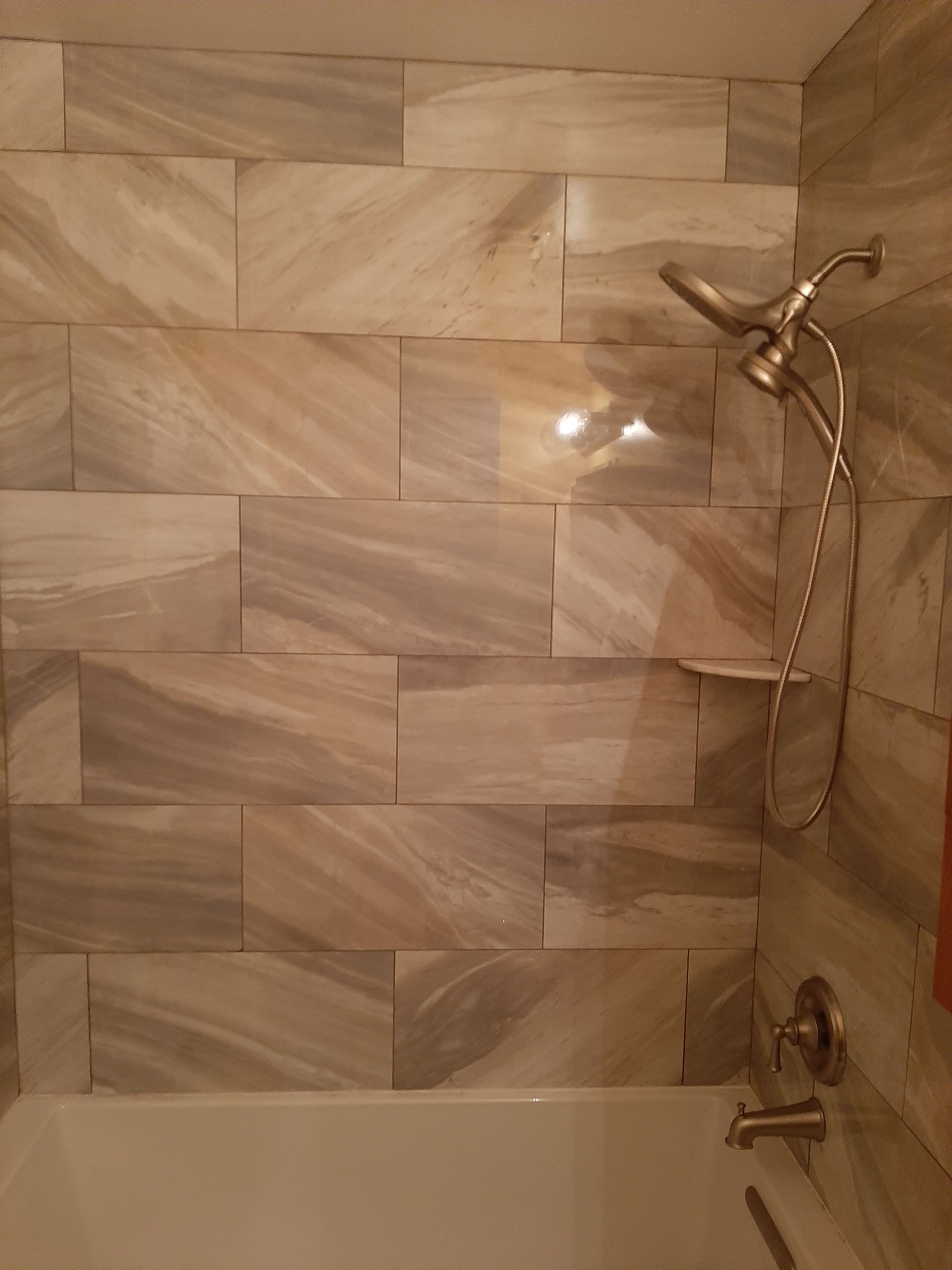A bathroom with a bathtub and a shower head.