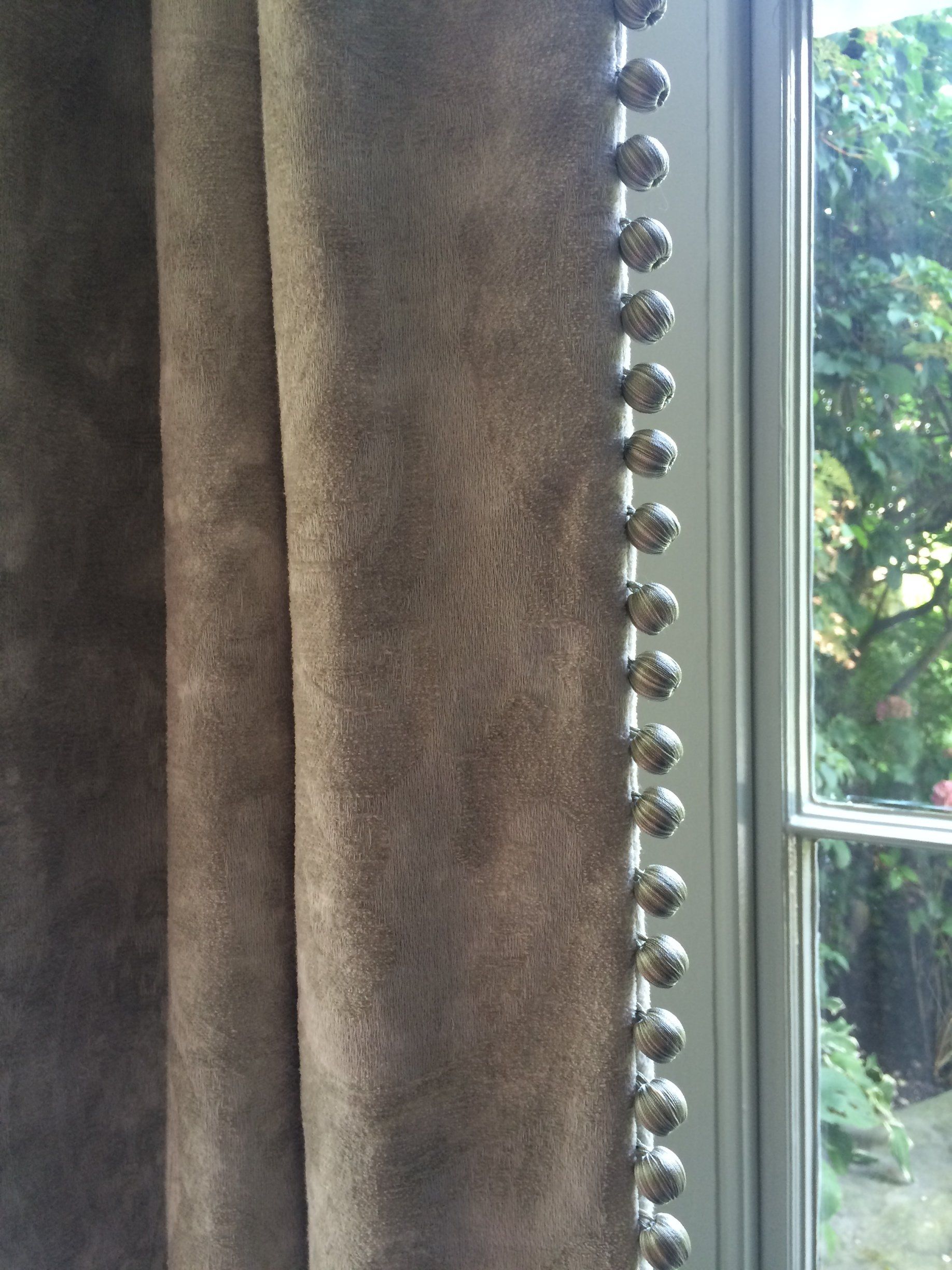 close up detail of silk bobble friinge on a curtain leading edge