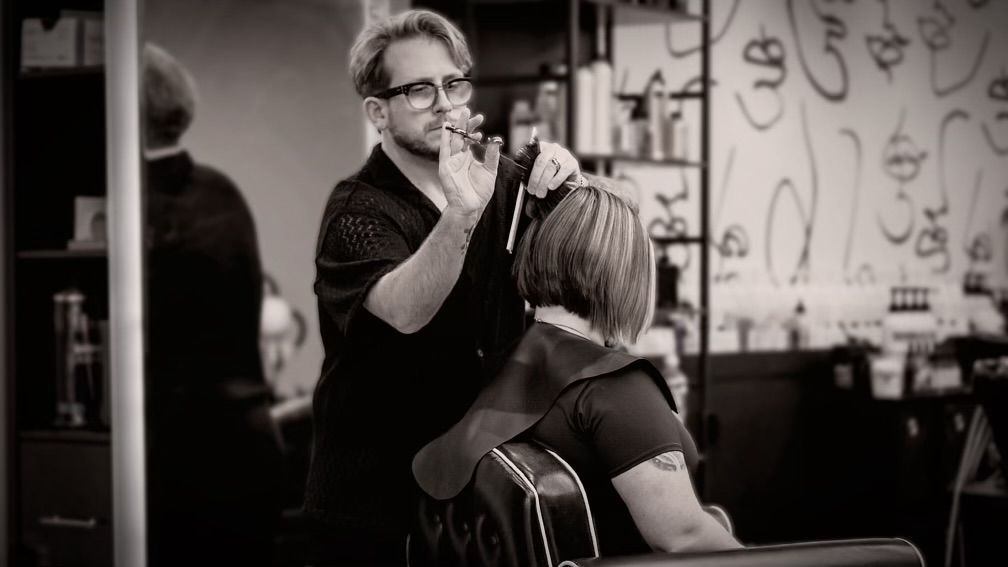 Michael Schulz is cutting a woman 's hair in a salon