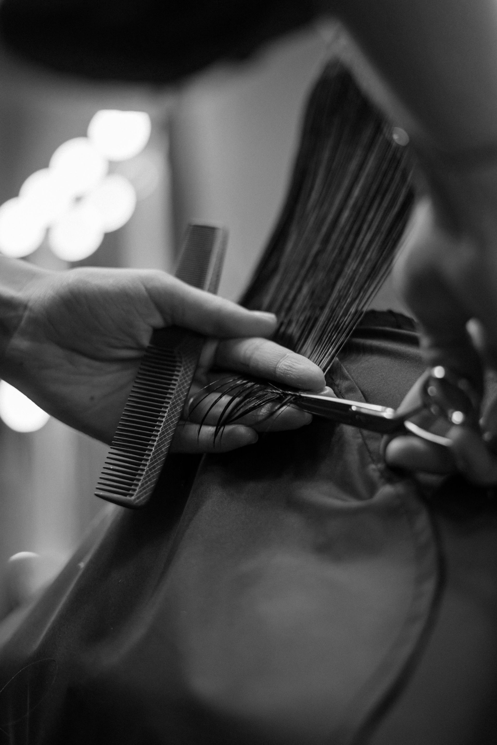 A  person getting their hair cut by a hairdresser