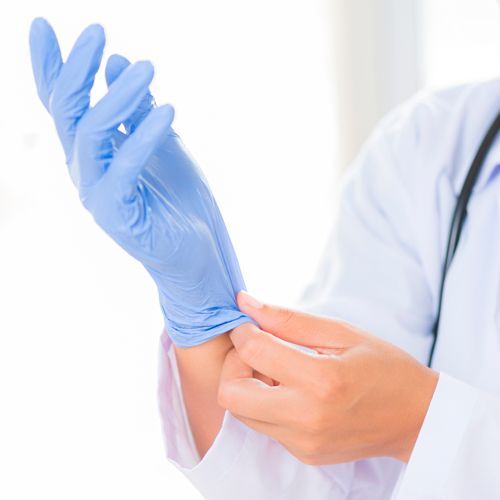 a doctor is putting on a pair of blue gloves .