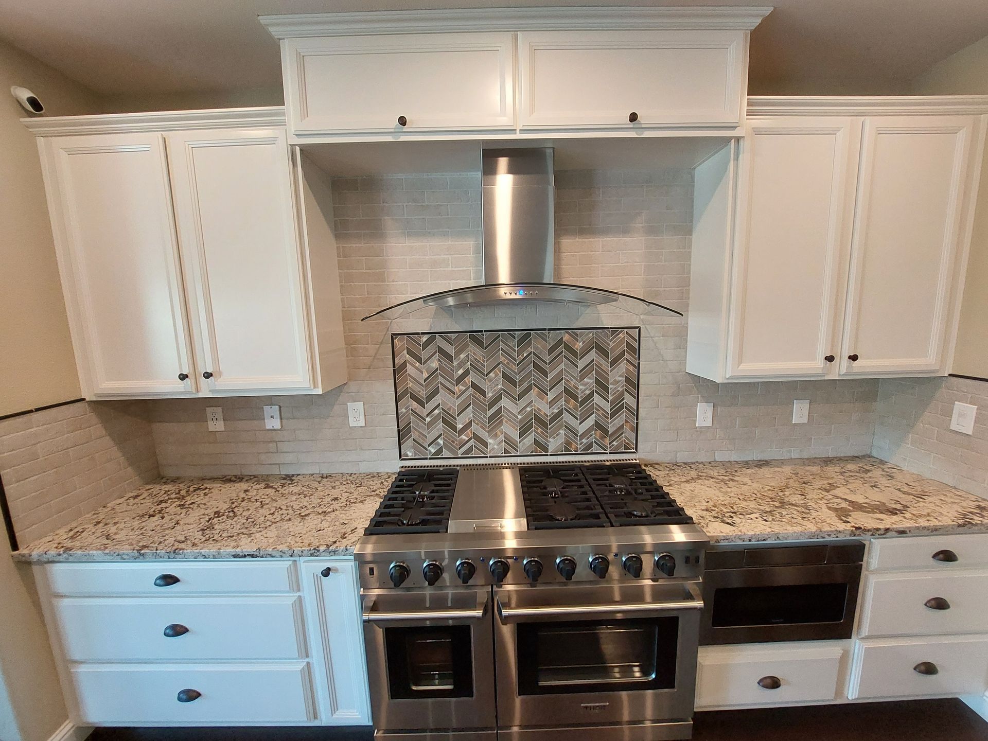 A kitchen with stainless steel appliances and white cabinets