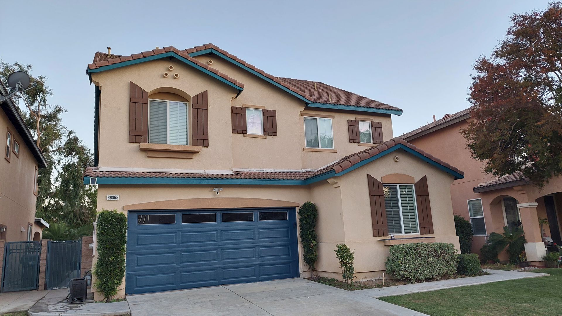 A house with a blue garage door and brown shutters
