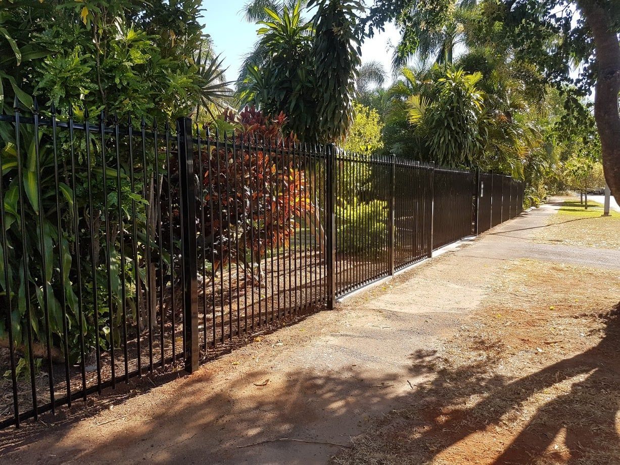 A Black Metal Fence Surrounds A Sidewalk — Fence Factory In Berrimah, NT