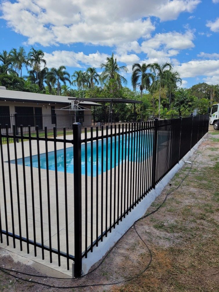 There Is A Large Swimming Pool in The Backyard of A House — Fence Factory In Tennant Creek, NT