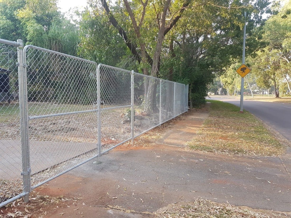 A Chain Link Fence is Along the Side Of A Road — Fence Factory In Berrimah, NT