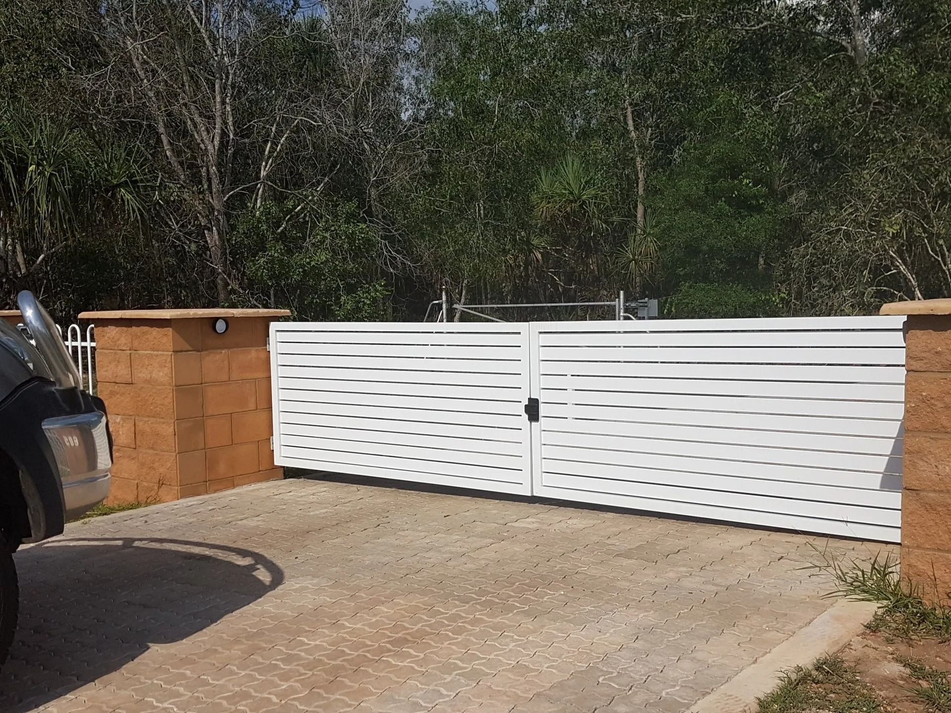 A Car is Parked in Front of a White Gate — Fence Factory In Berrimah, NT