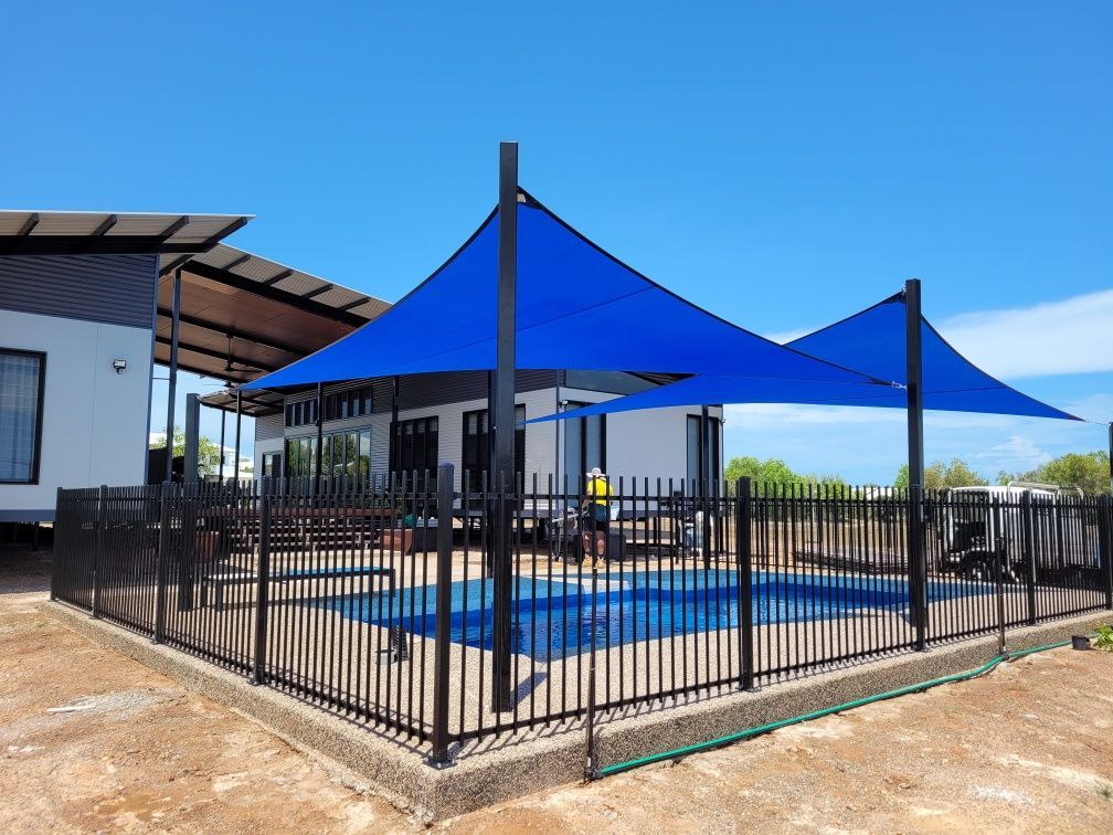A Large Swimming Pool with A Fence Around It — Fence Factory In Palmerston, NT
