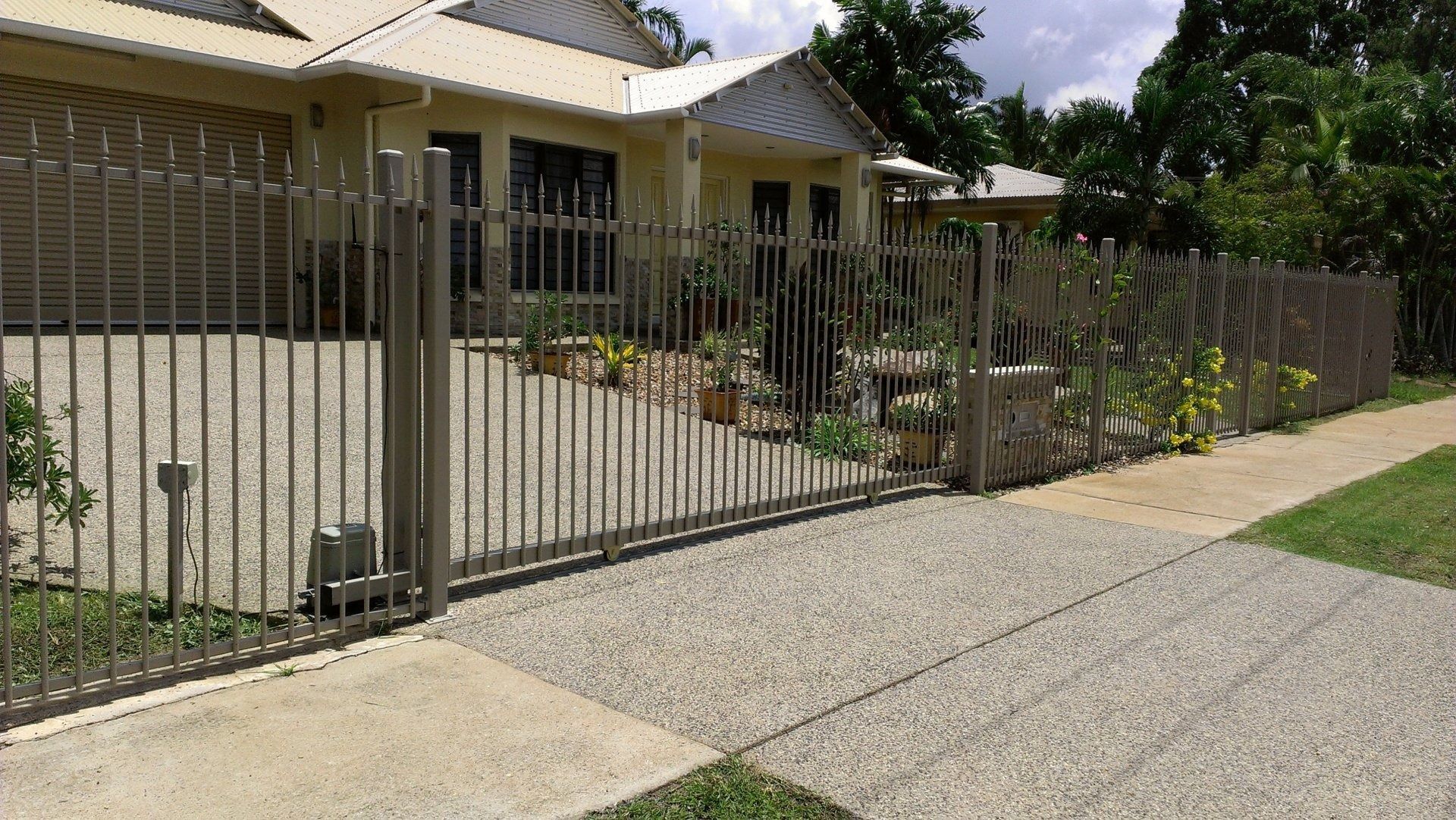 A grey metal fence is surrounding a house — Fence Factory In Tennant Creek, NT