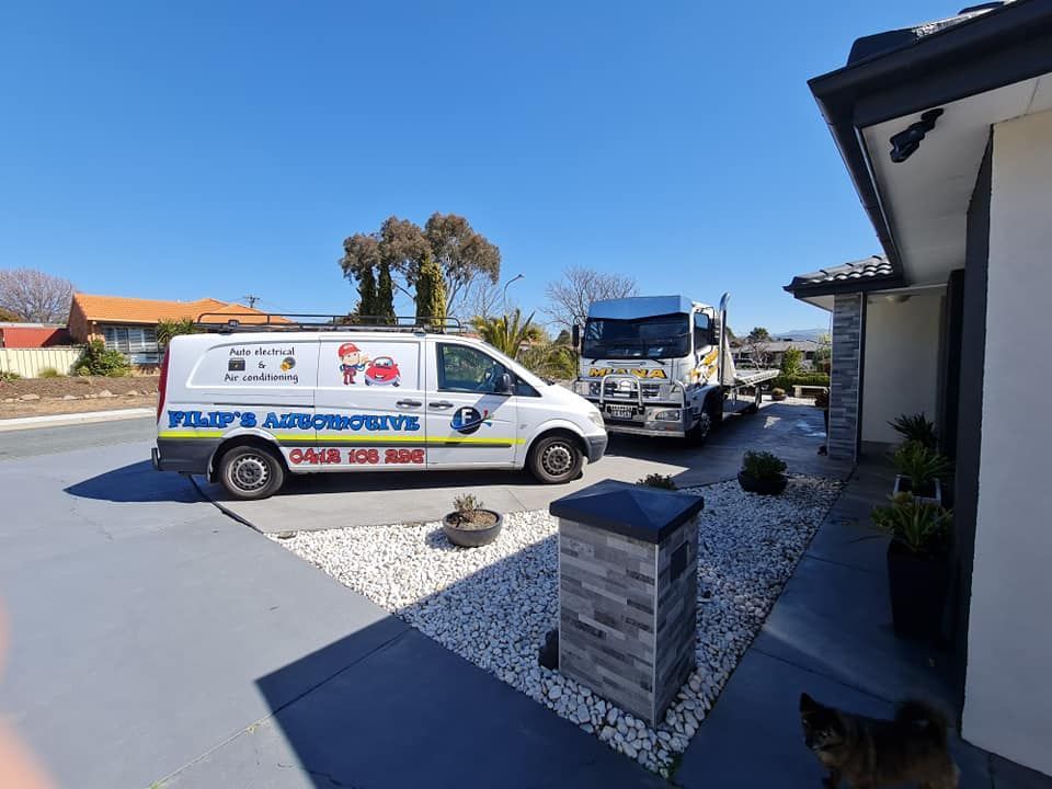A Van And A Truck Are Parked In Front Of A House — Filip's Automotive in Crestwood, NSW