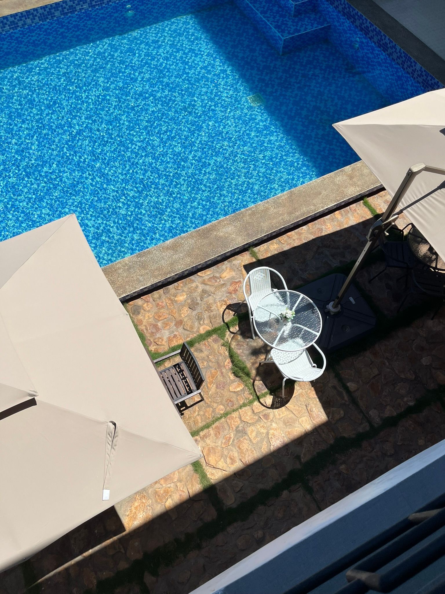 An aerial view of a swimming pool with umbrellas and chairs.