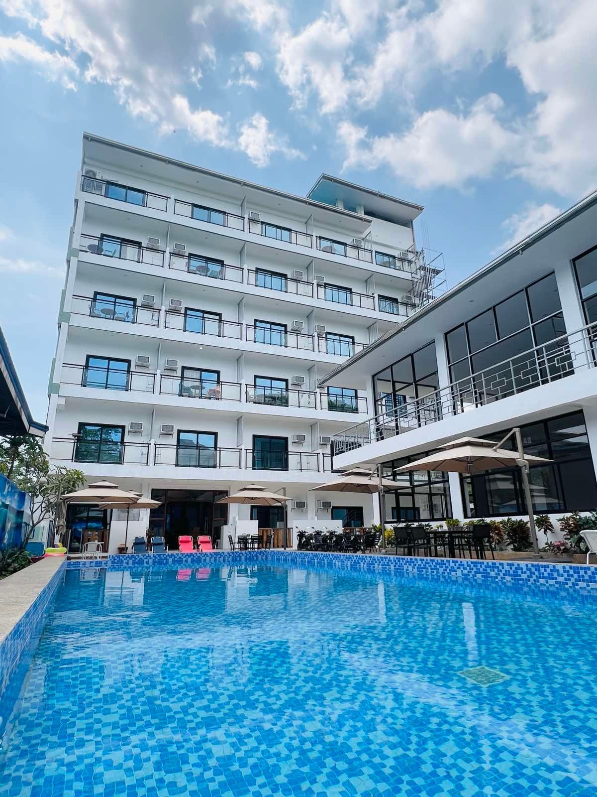 A large building with a swimming pool in front of it.