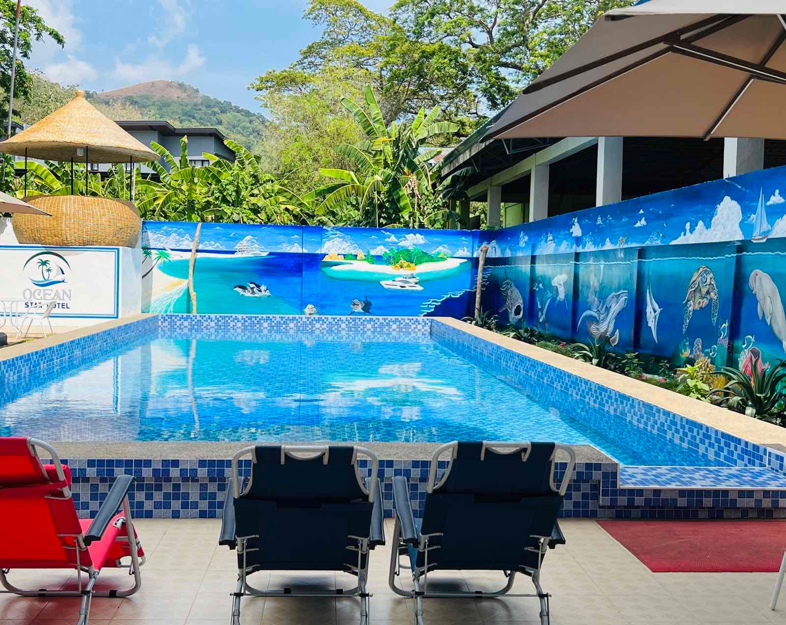 A large swimming pool with chairs and umbrellas around it