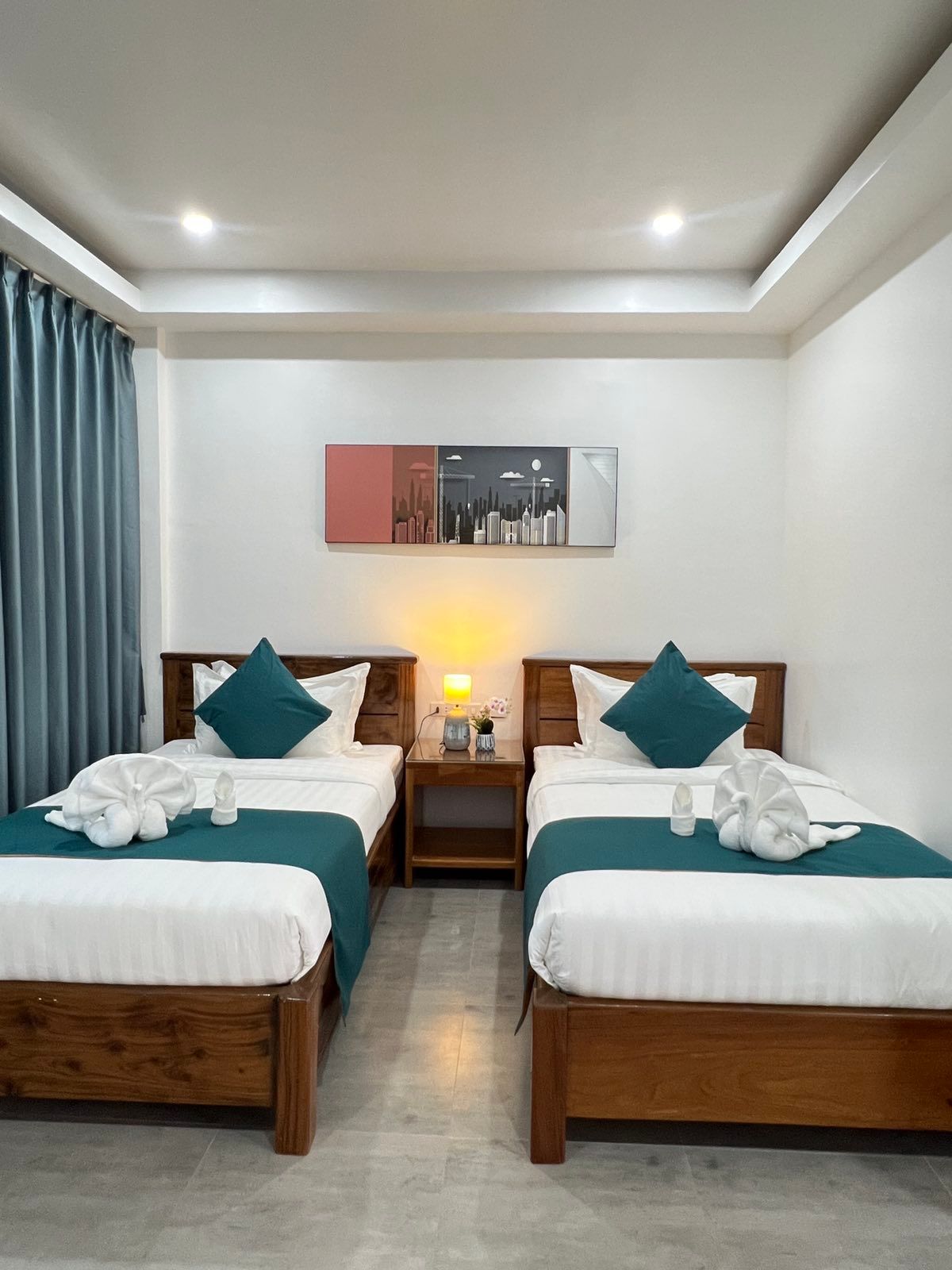 A hotel room with two beds and a painting on the wall.