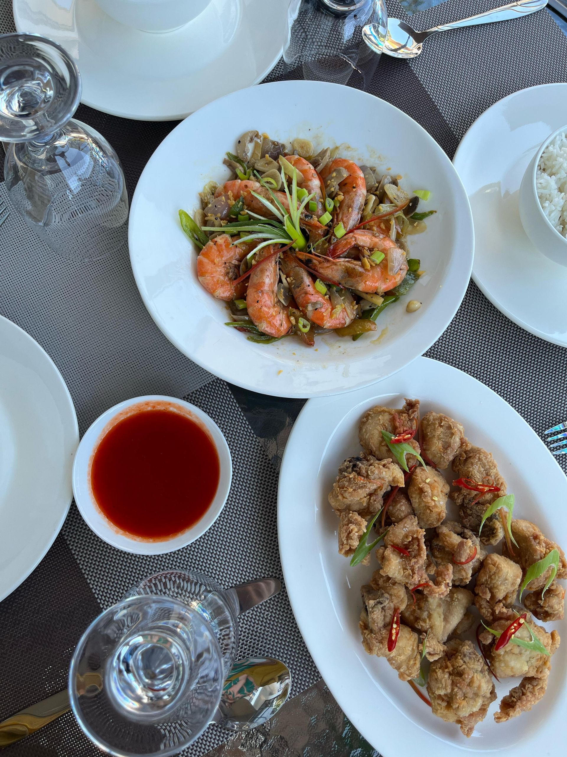 A table topped with plates of food and wine glasses.
