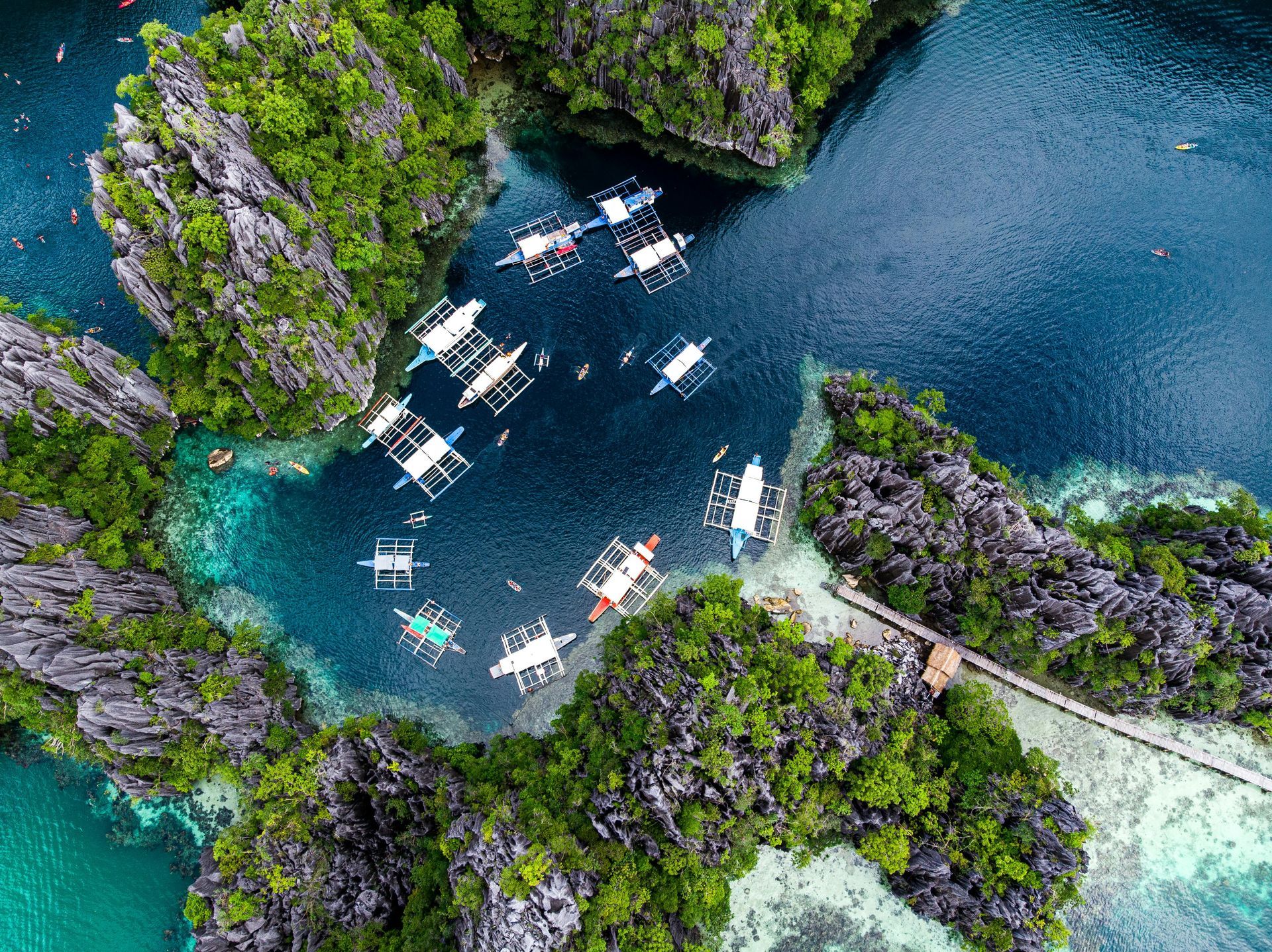 An aerial view of a tropical island with boats in the water.