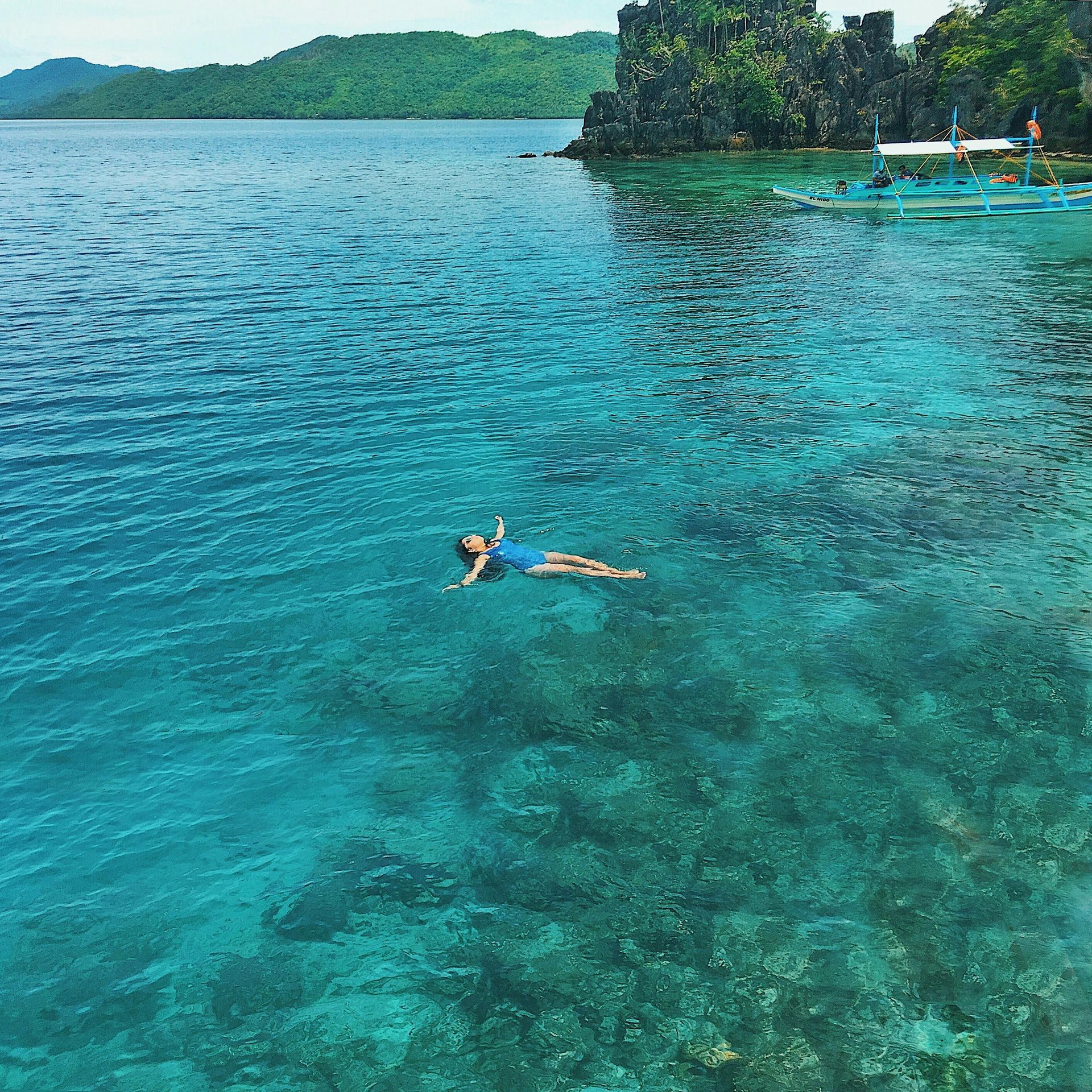 A woman is floating on her back in a body of water.