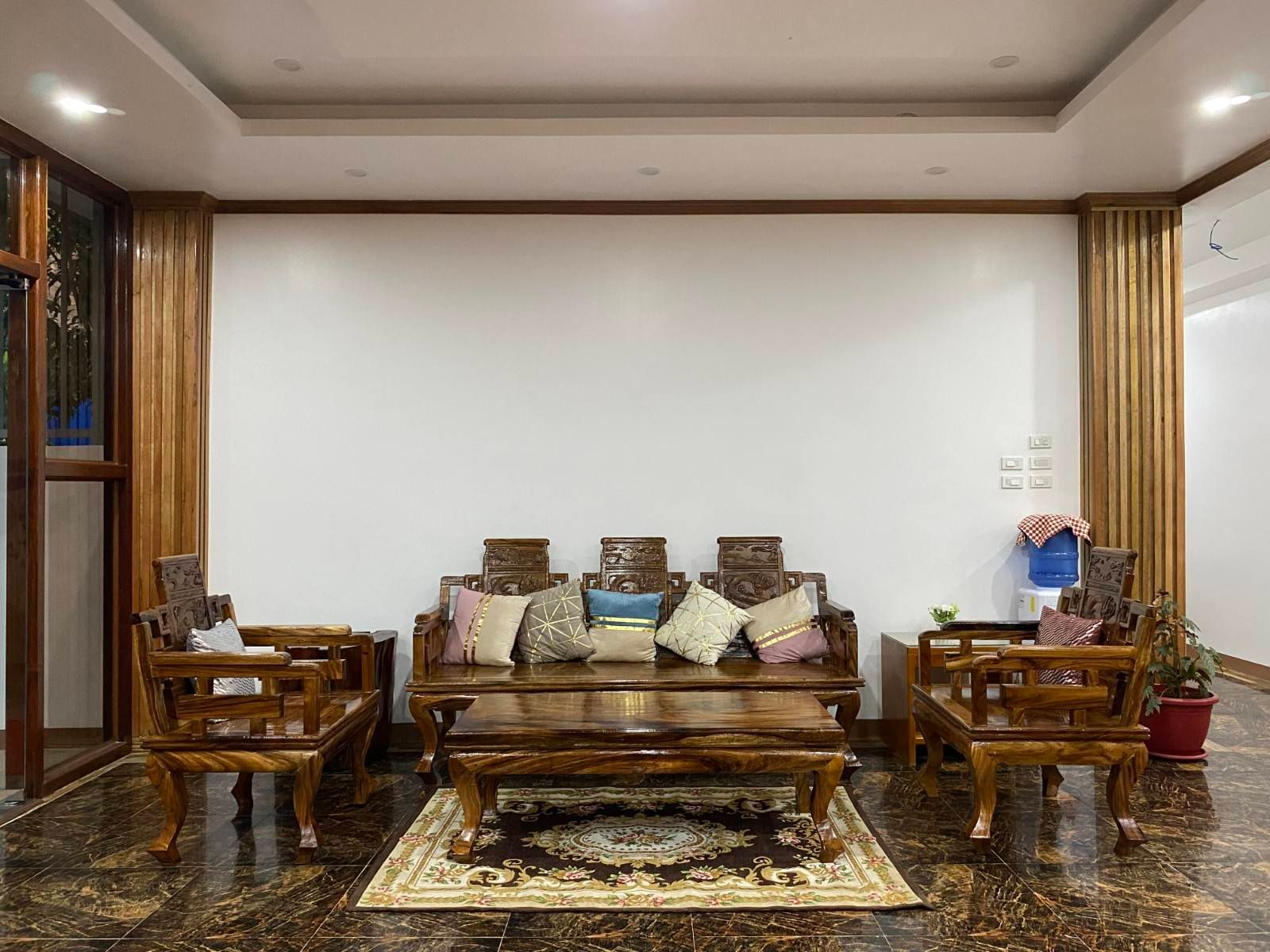 A living room with a couch , chairs , and a table.