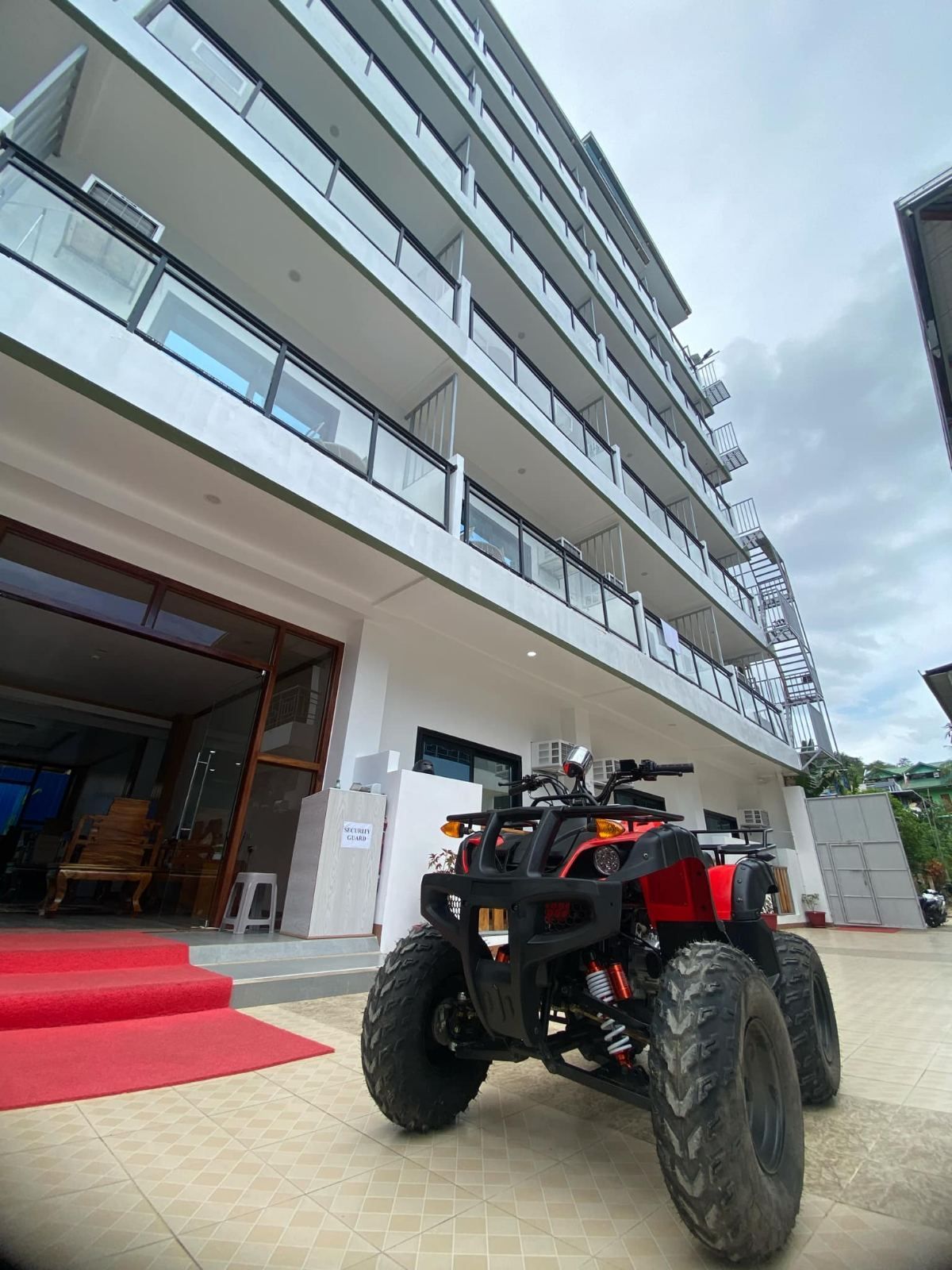 A red atv is parked in front of a building.
