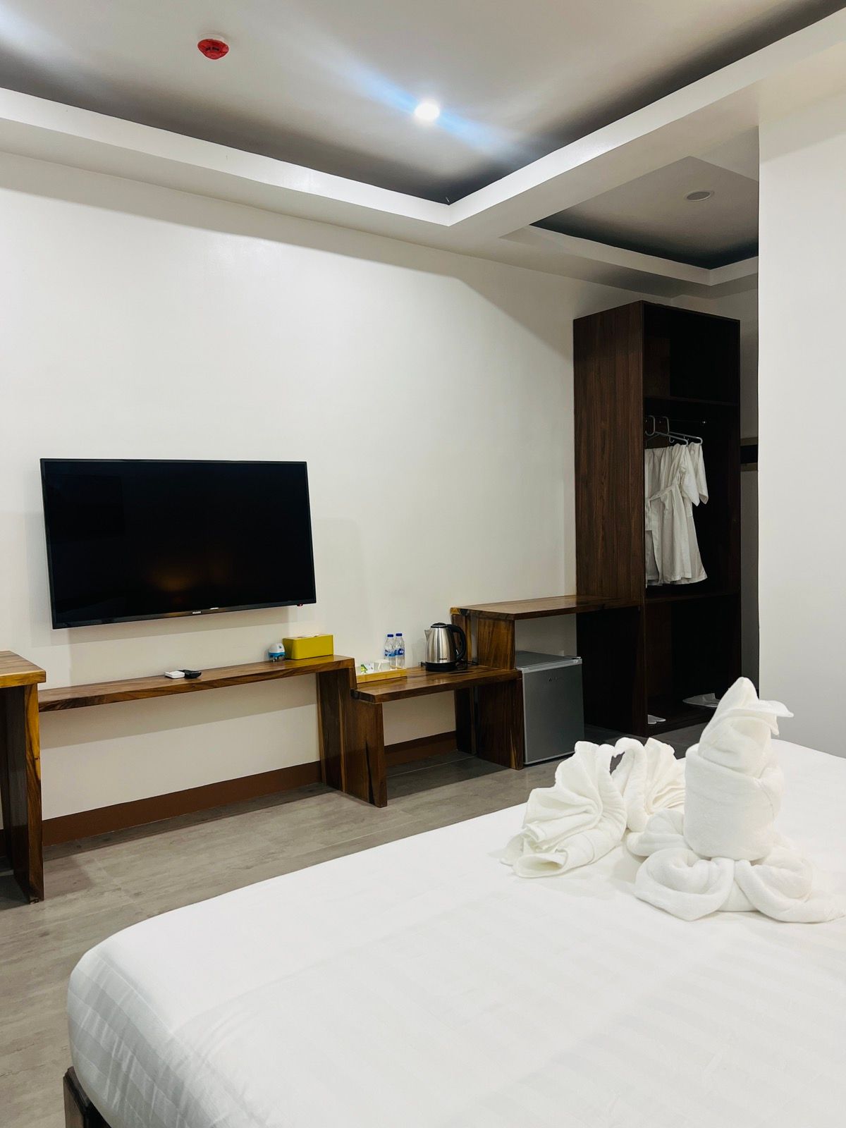 A hotel room with a bed and a flat screen tv.