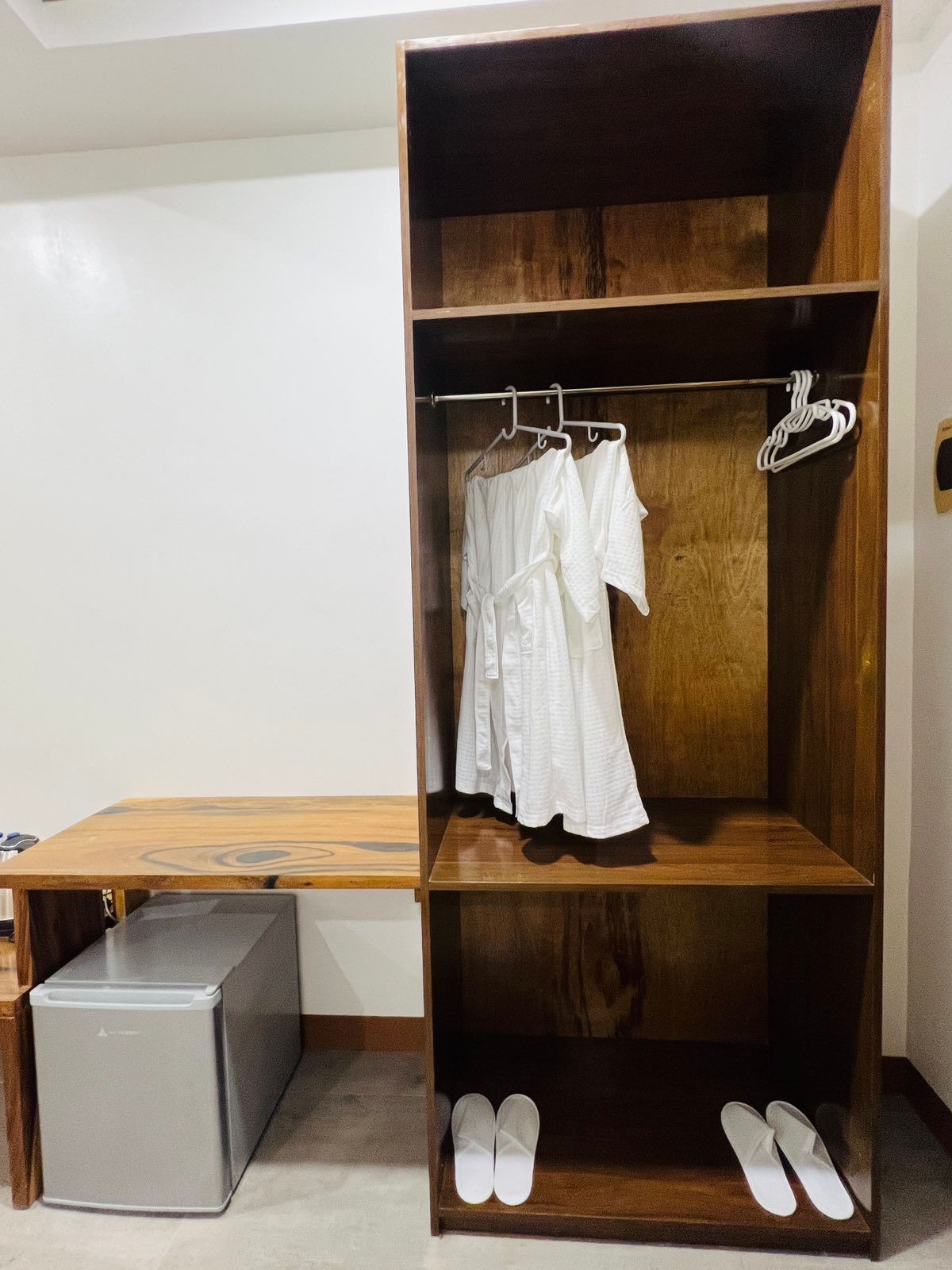 A closet with clothes and slippers in it