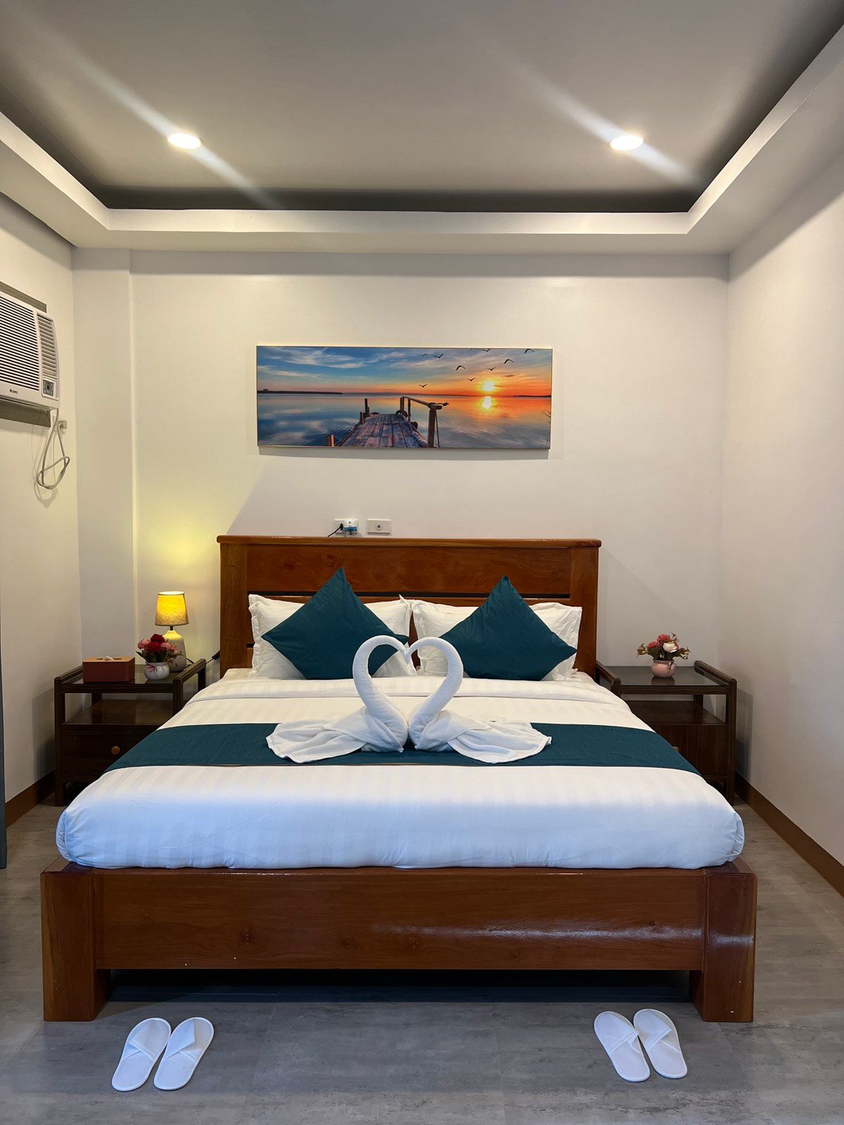 A bedroom with a king size bed and a painting on the wall above it.