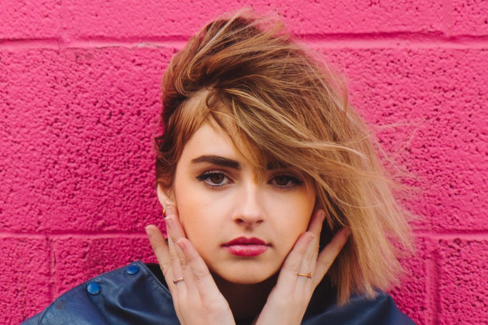 woman by pink wall