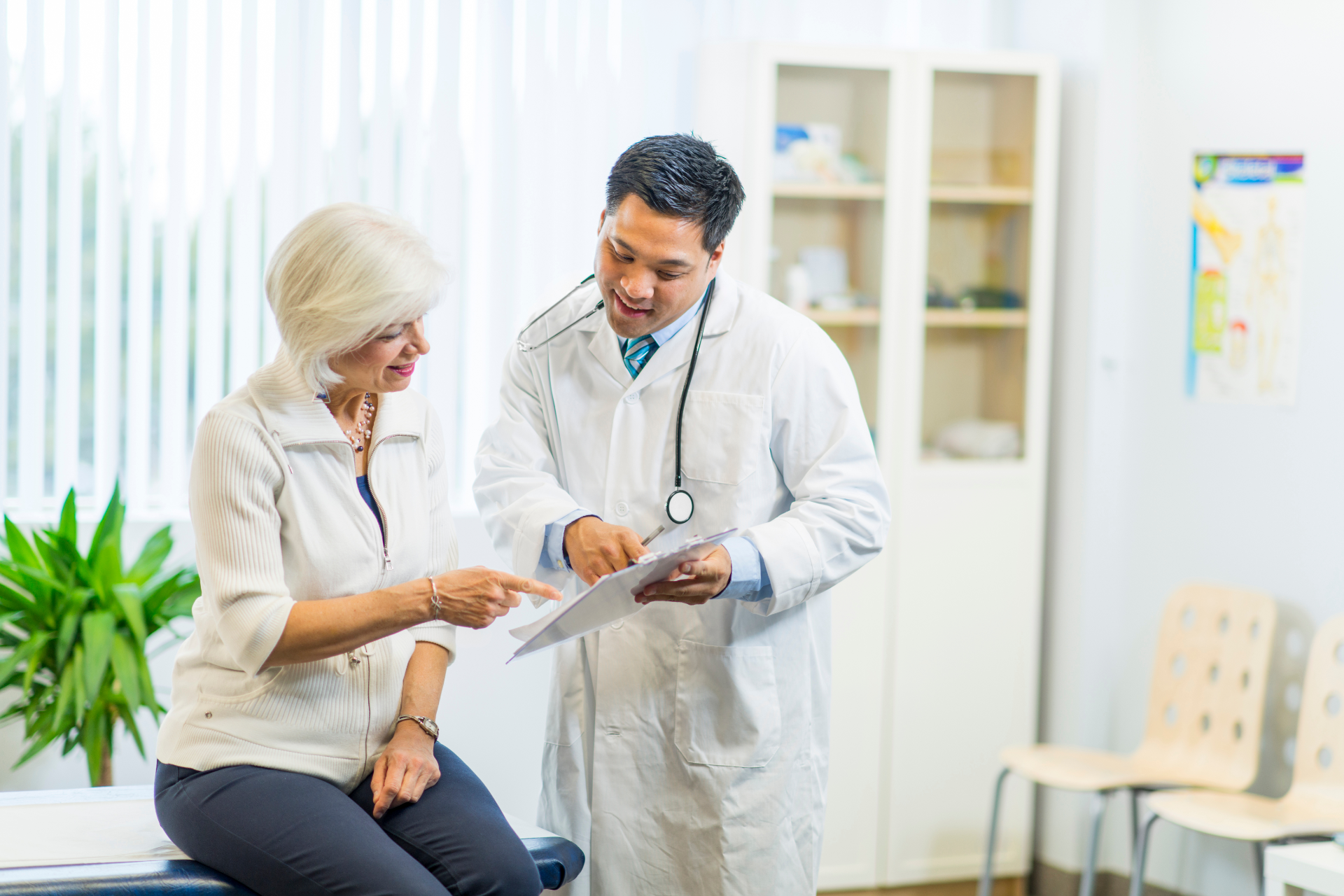 Doctor showing patient paperwork in a clinic. Both are smiling.