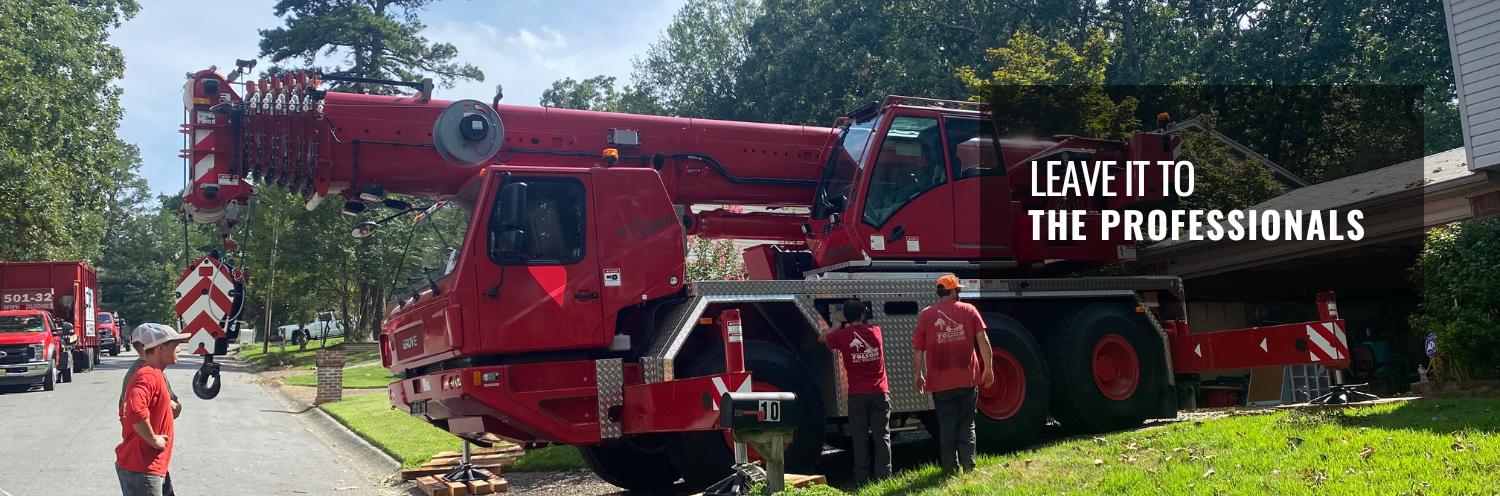 Red crane truck at roadside with workers and sign reading “LEAVE IT TO THE PROFESSIONALS.”