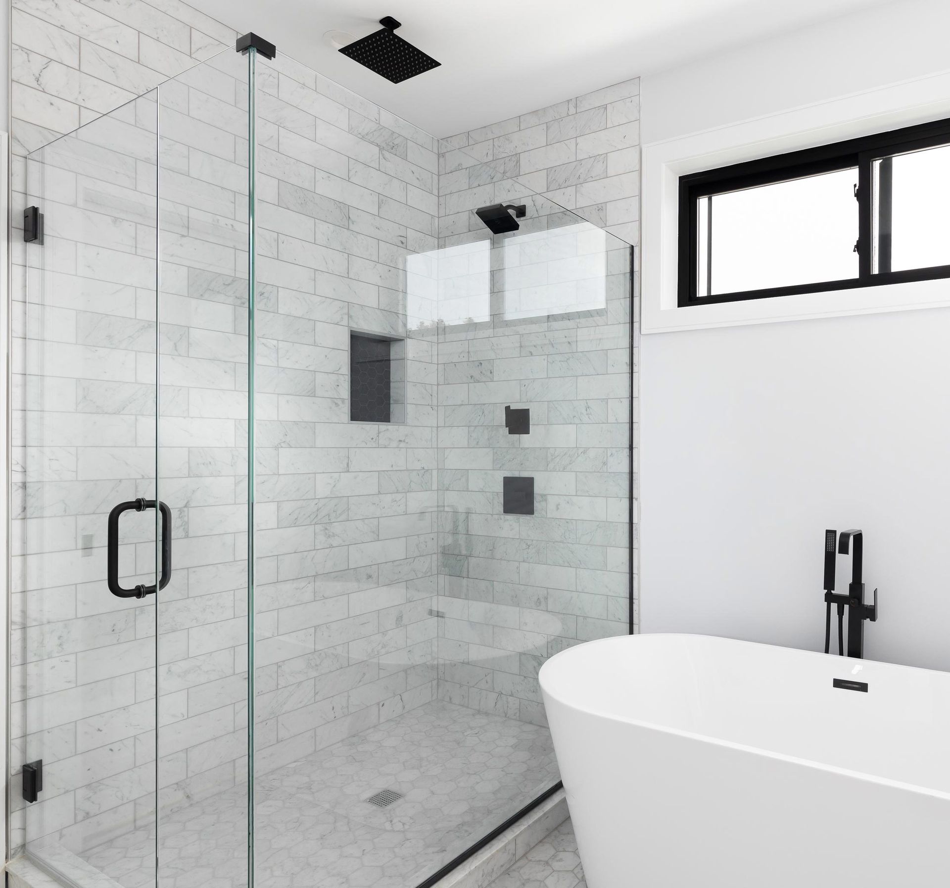 luxury shower and freestanding bathtub with glass surrounding the shower.