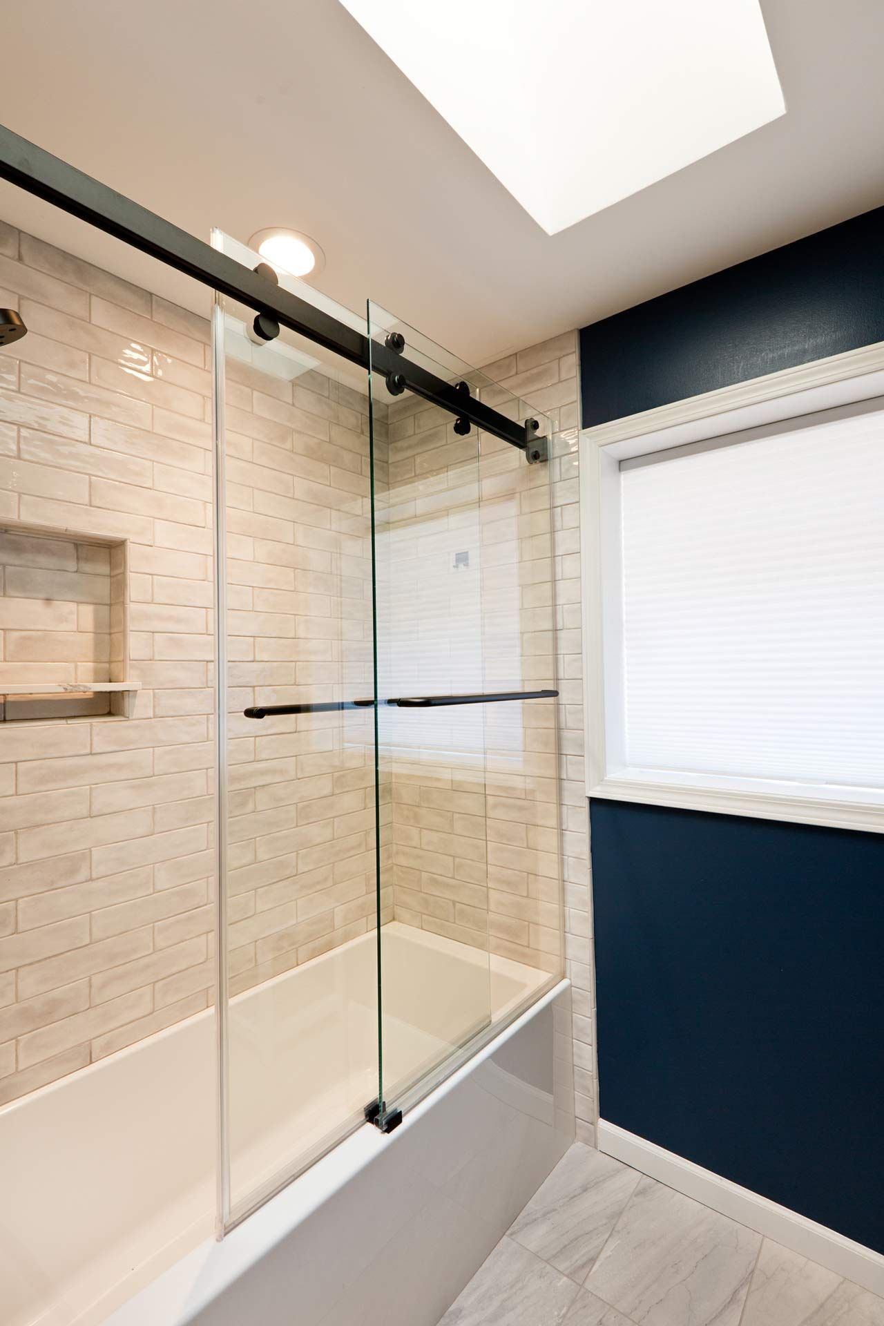 A contemporary modern bathroom design, featuring a glass shower door.