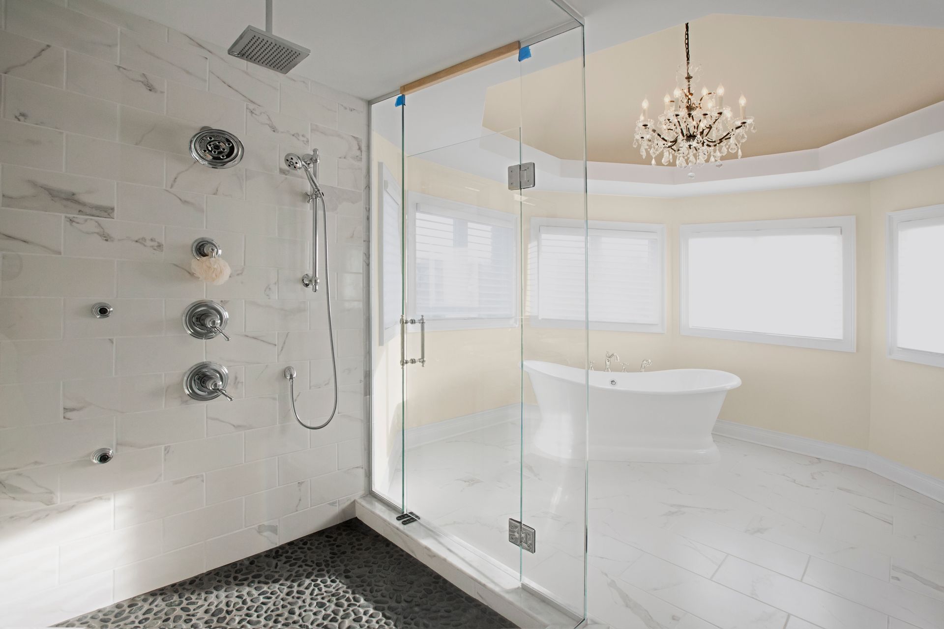 Elegant marble master bathroom featuring sleek glass shower doors for a modern, spacious look.